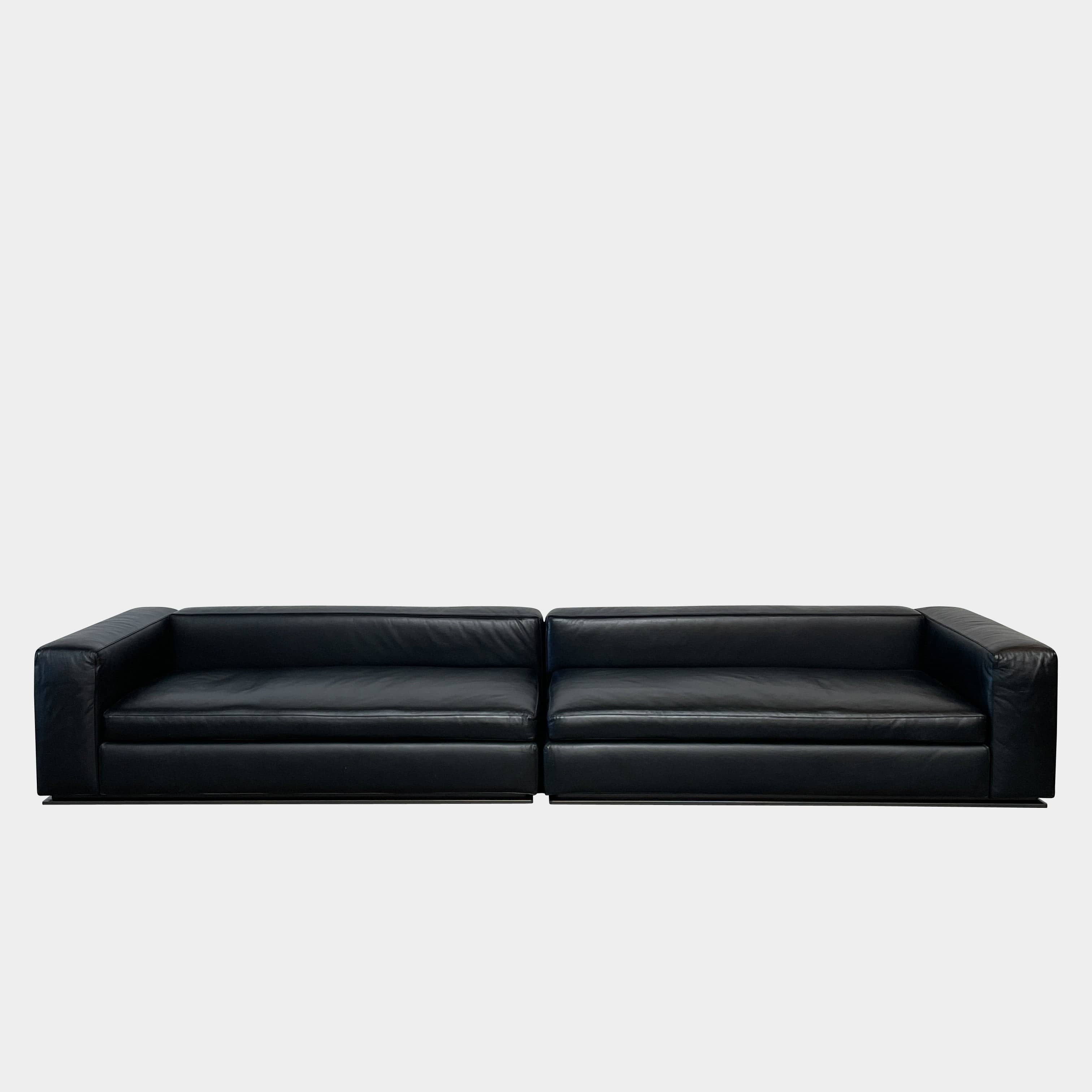 A Minotti Hamilton Black Leather Sofa with multiple cushions, designed by Rodolfo Dordoni, isolated on a white background.