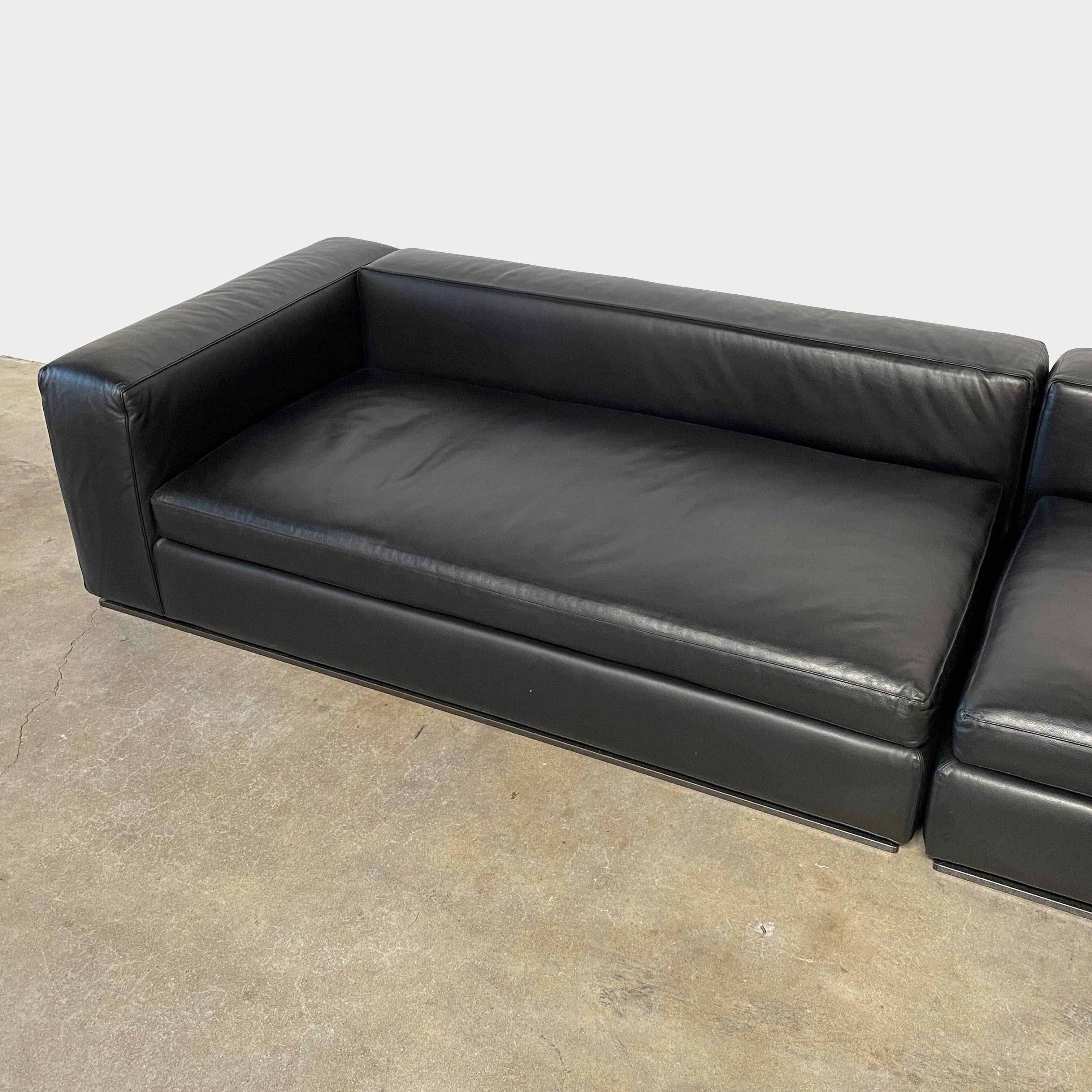 A Minotti Hamilton Black Leather Sofa with multiple cushions, designed by Rodolfo Dordoni, isolated on a white background.