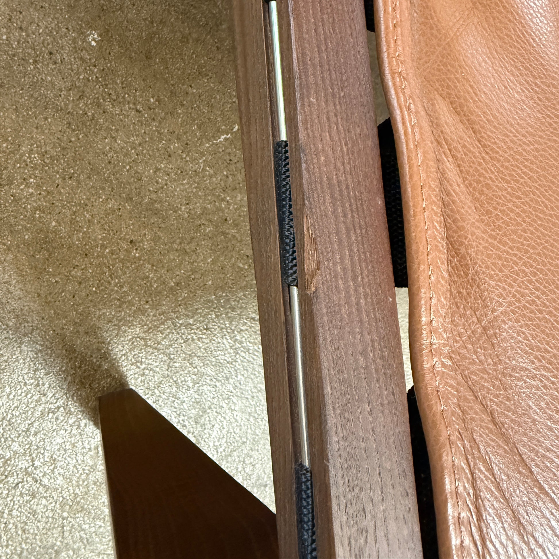 A contemporary B&B Italia JJ Armchair with brown leather seat and backrest, angular armrests, and a dark wooden frame, designed by Antonio Citterio. Set against a plain white background.