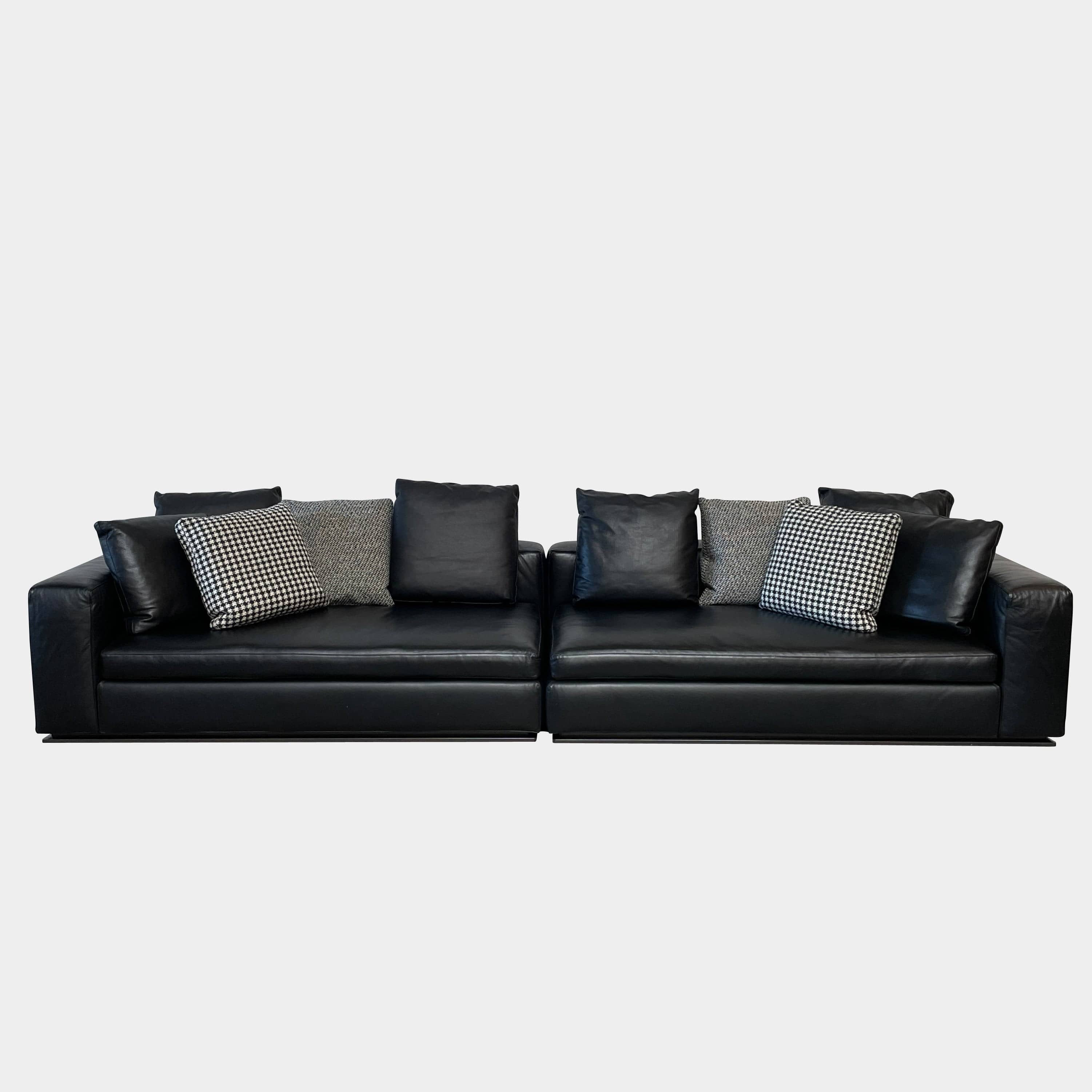 A Minotti Hamilton Black Leather Sofa with multiple cushions, designed by Rodolfo Dordoni, isolated on a white background.