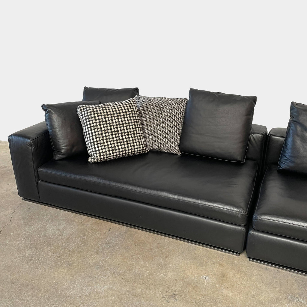 A Minotti Hamilton Black Leather Sofa with multiple cushions, designed by Rodolfo Dordoni, isolated on a white background.