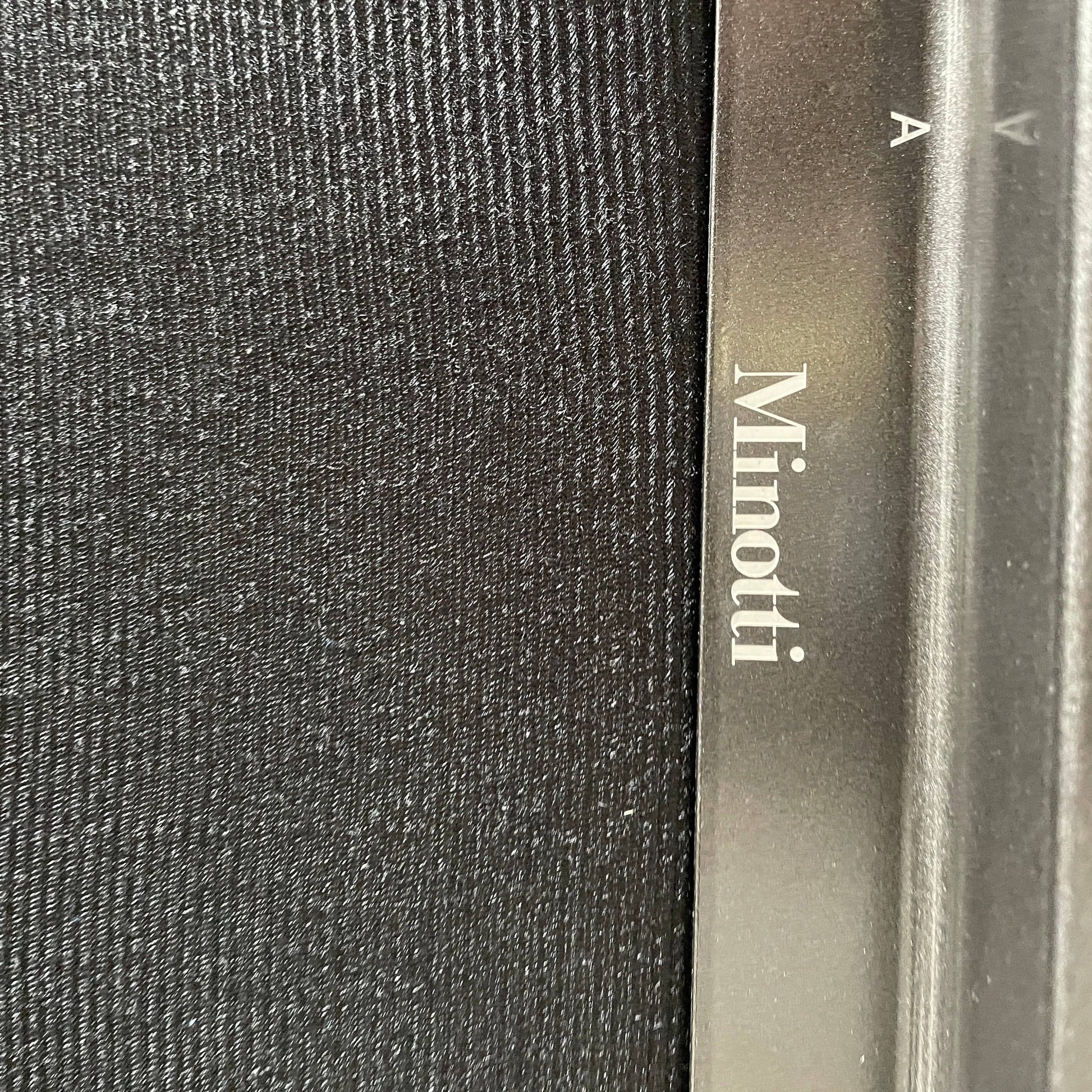 A Minotti Hamilton Black Leather Sofa with multiple cushions, designed by Rodolfo Dordoni, isolated on a white background.