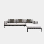 The Tribu Natal Alu Outdoor Sectional Sofa by Tribú features light gray cushions, five dark gray throw pillows, and a sleek black aluminum frame—perfect for adding modern style to your patio.
