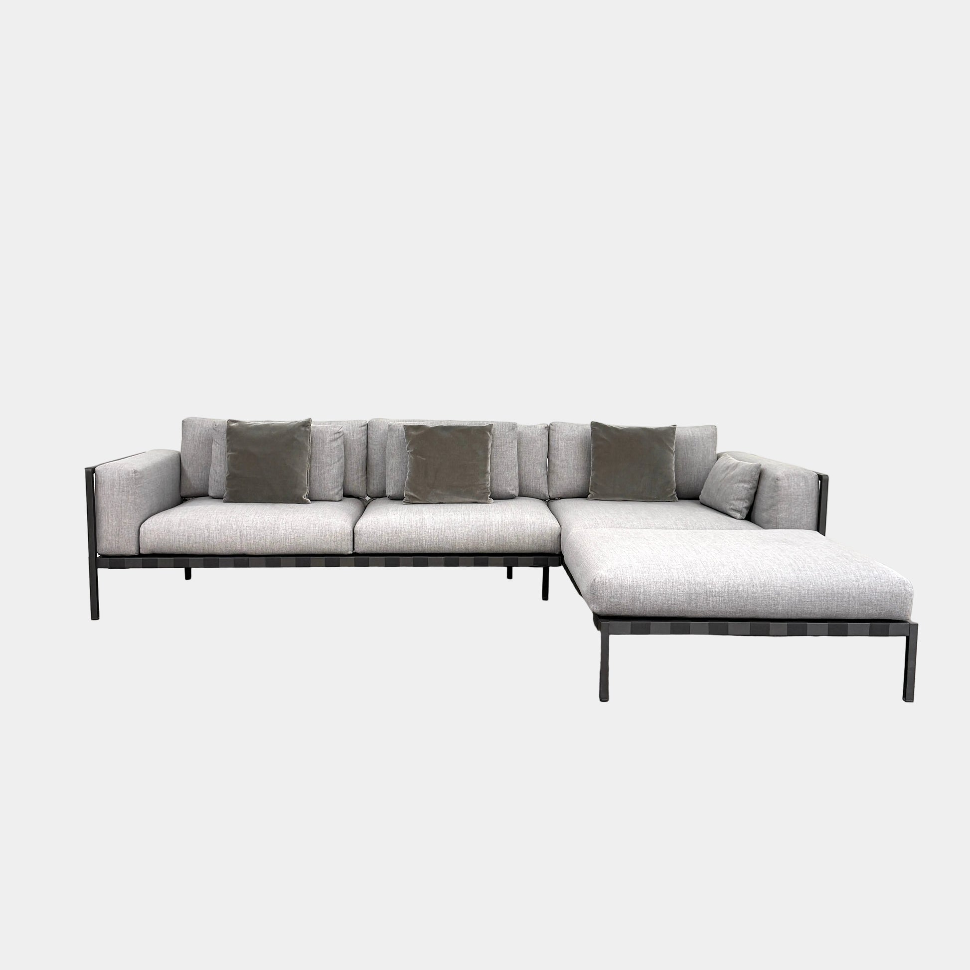 The Tribu Natal Alu Outdoor Sectional Sofa by Tribú features light gray cushions, five dark gray throw pillows, and a sleek black aluminum frame—perfect for adding modern style to your patio.