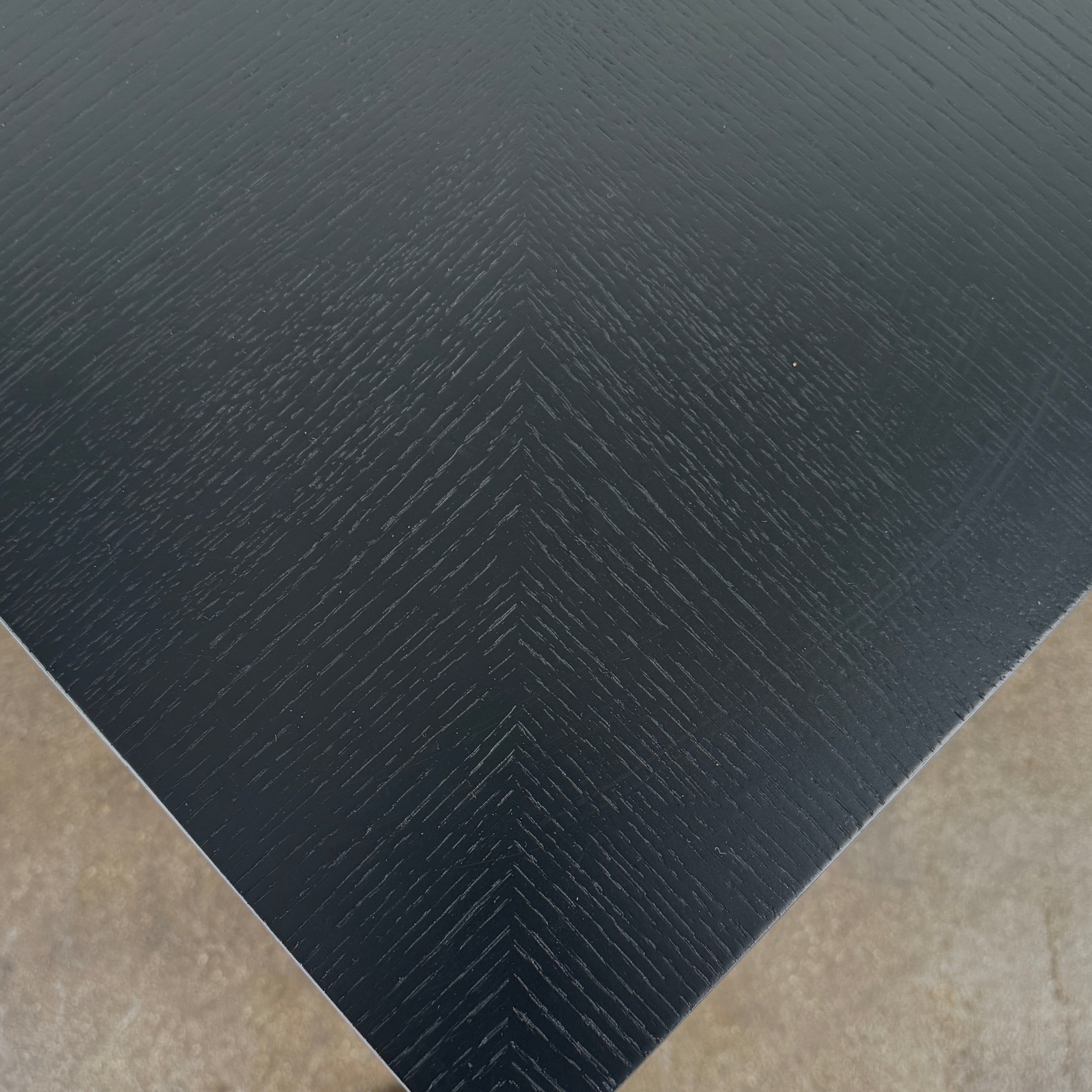 The Rimadesio Long Island Table by Rimadesio features a square black oak top with a dark wood finish, four slender legs, and modern Italian design, displayed against a plain white background.