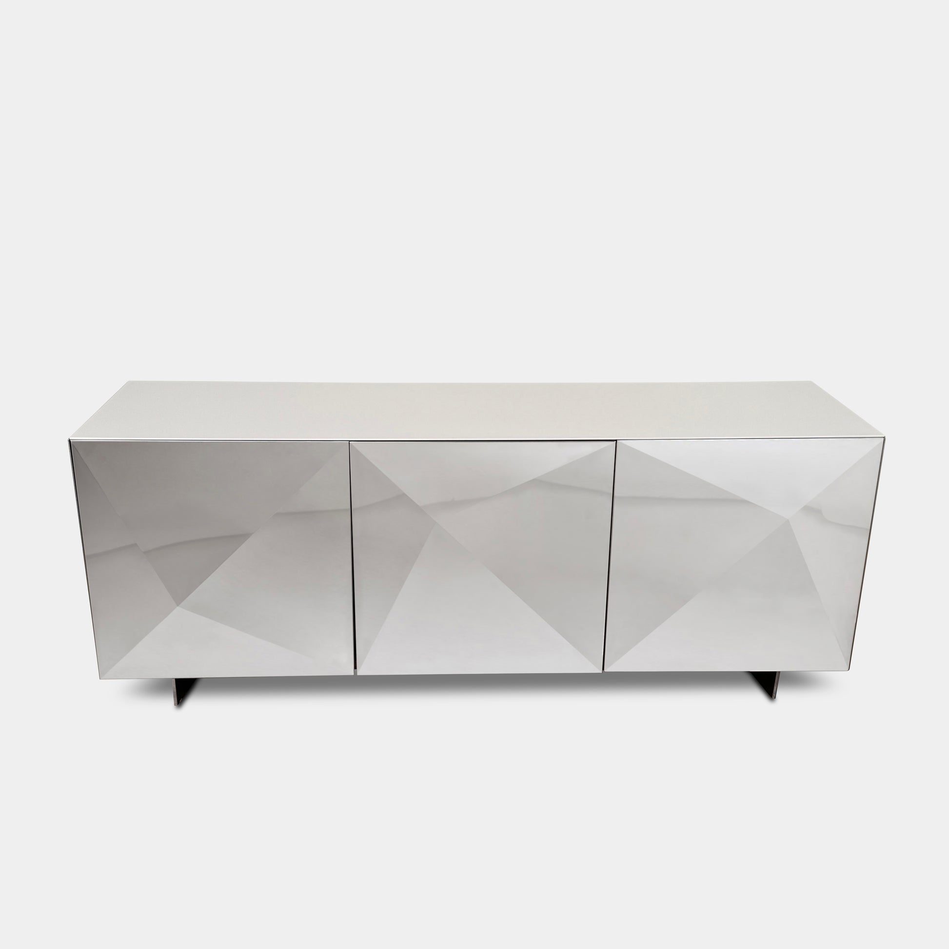 The Riflessi Cubric Sideboard by Riflessi features three mirrored doors and a geometric jagged top edge, shown here against a plain white wall on a concrete floor.