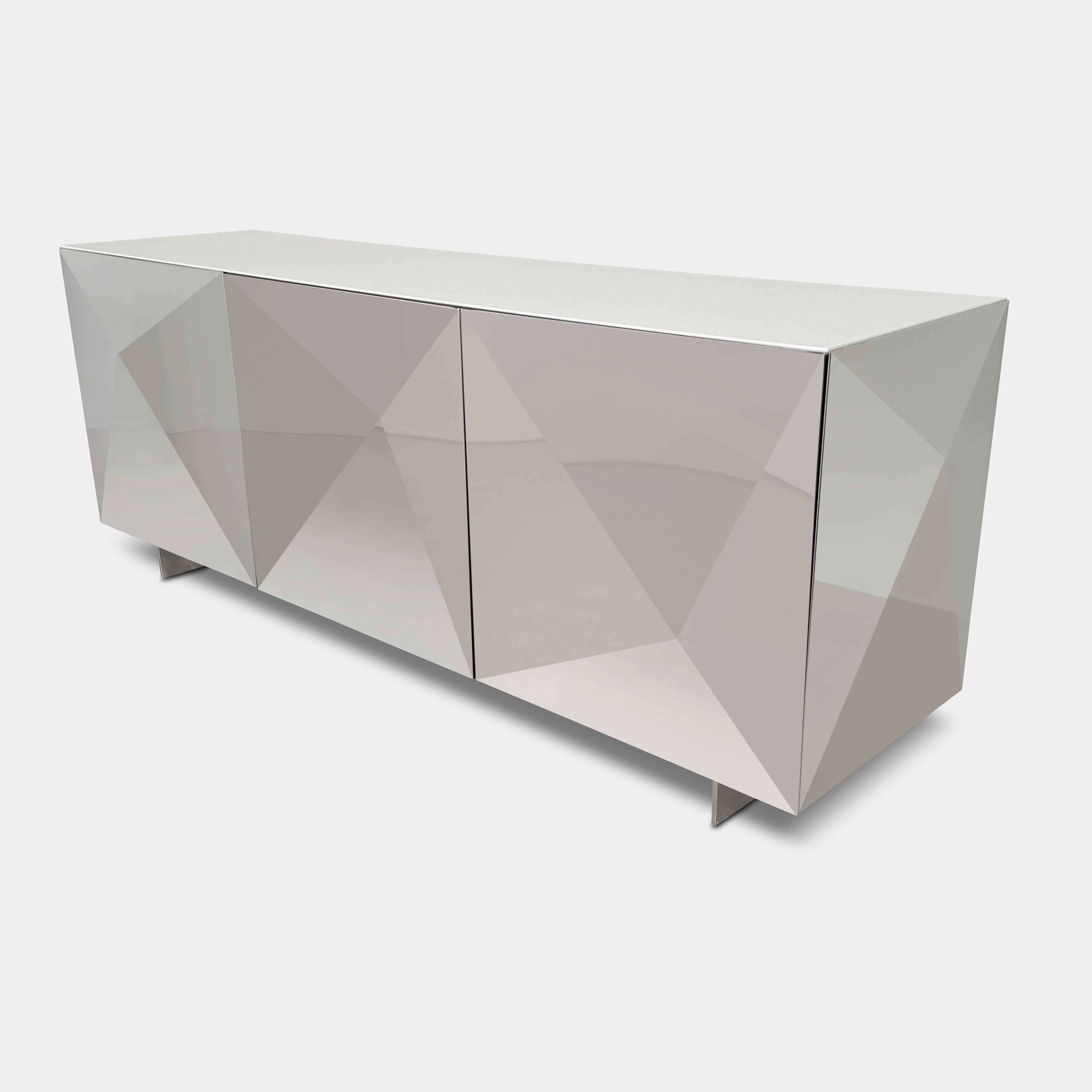 The Riflessi Cubric Sideboard by Riflessi features three mirrored doors and a geometric jagged top edge, shown here against a plain white wall on a concrete floor.