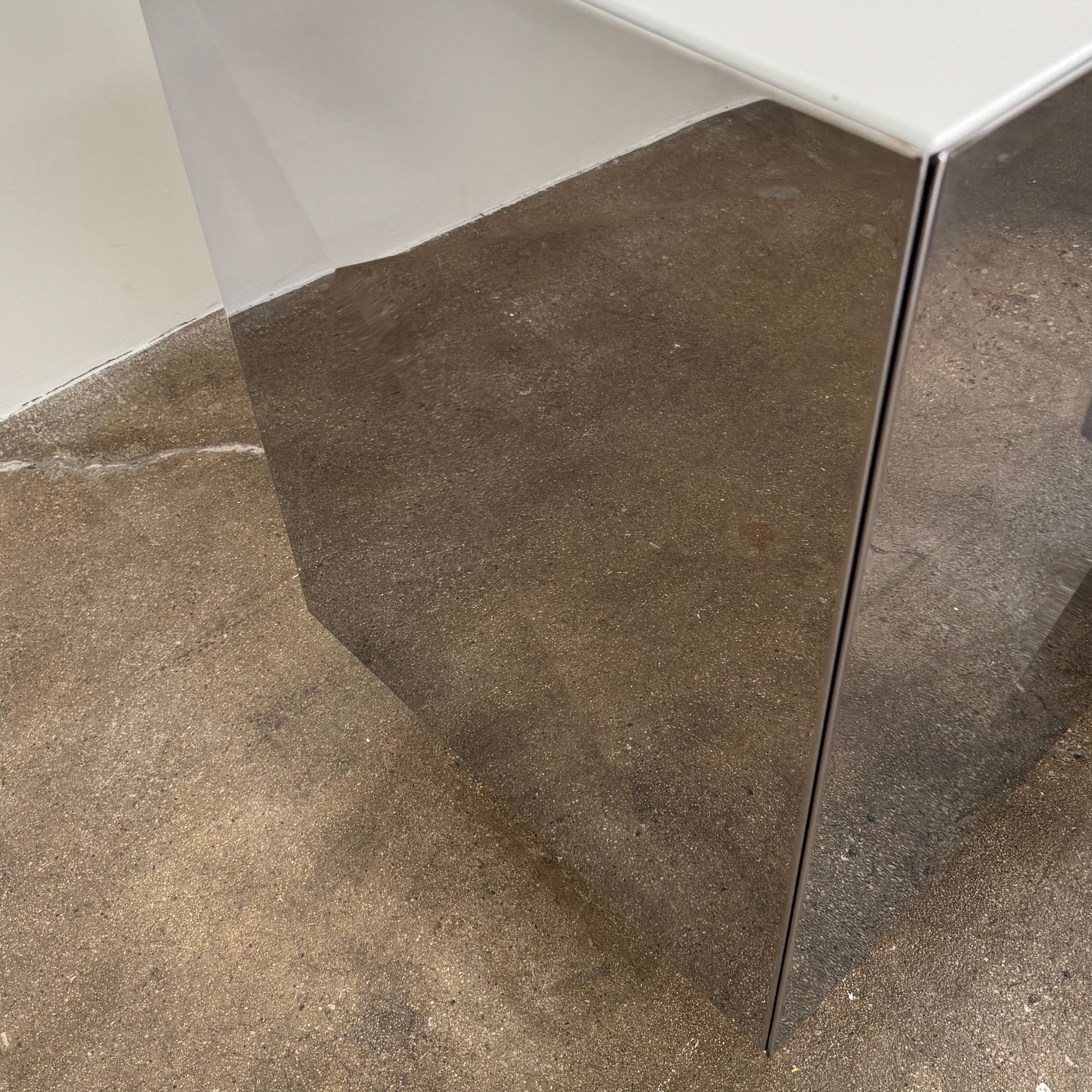 The Riflessi Cubric Sideboard by Riflessi features three mirrored doors and a geometric jagged top edge, shown here against a plain white wall on a concrete floor.