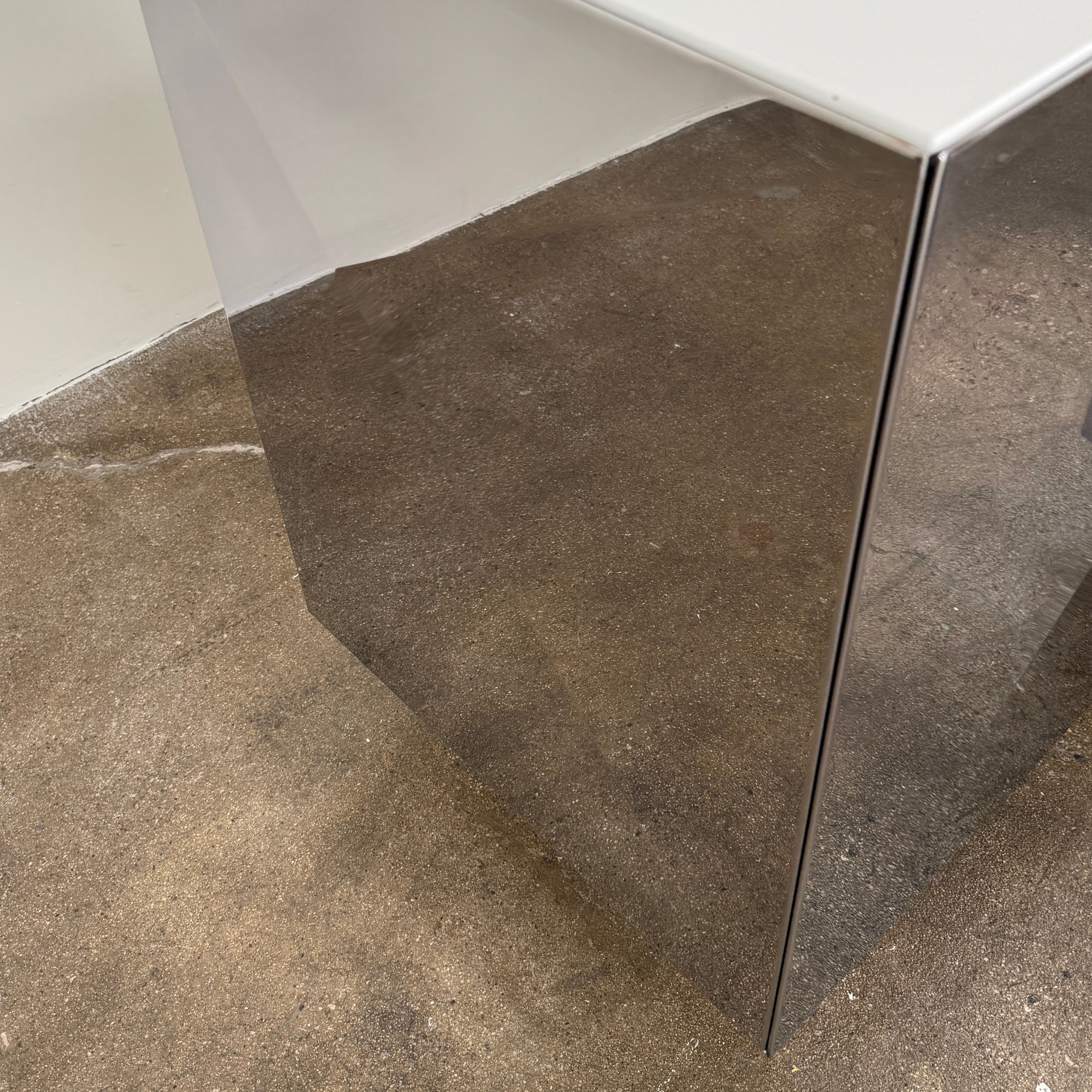 The Riflessi Cubric Sideboard by Riflessi features three mirrored doors and a geometric jagged top edge, shown here against a plain white wall on a concrete floor.