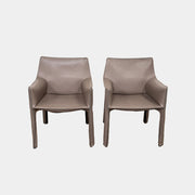 A pair of Cassina Cab 413 Dining Chairs by Cassina, featuring taupe leather and a modern design, are positioned side by side against a plain white background.