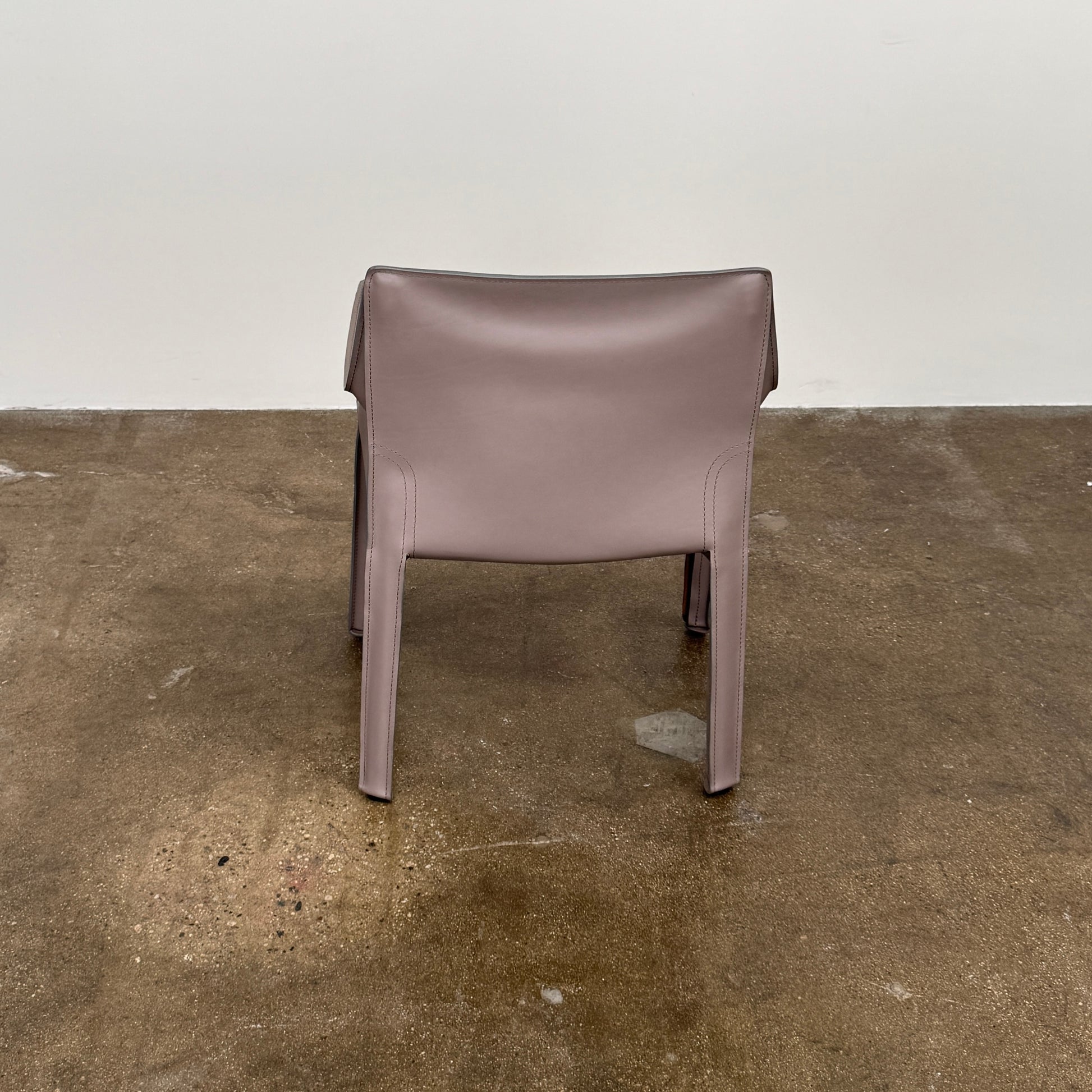 A pair of Cassina Cab 413 Dining Chairs by Cassina, featuring taupe leather and a modern design, are positioned side by side against a plain white background.