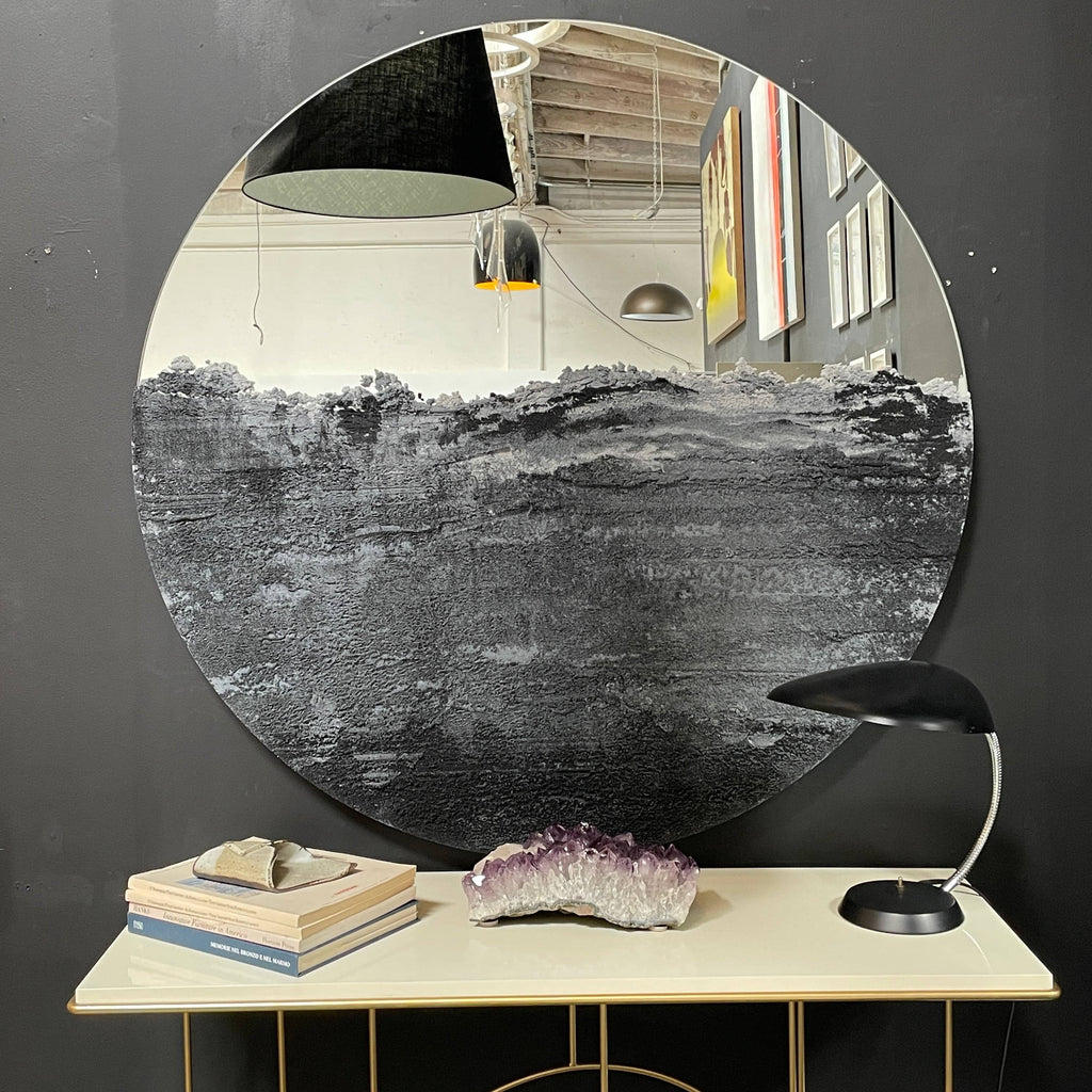 A Fernando Mastrangelo Studio Drift 48" Mirror with a black and white painting on it.