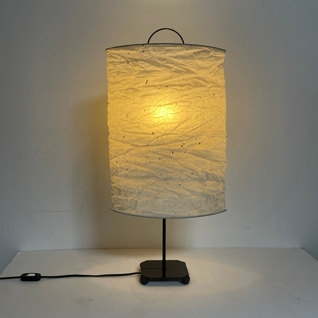 A close-up of a wrinkled white Toshiyuki Kita KYO Table Lamp made from handmade washi paper with a black metal handle, designed by Toshiyuki Kita, set against a plain white background.