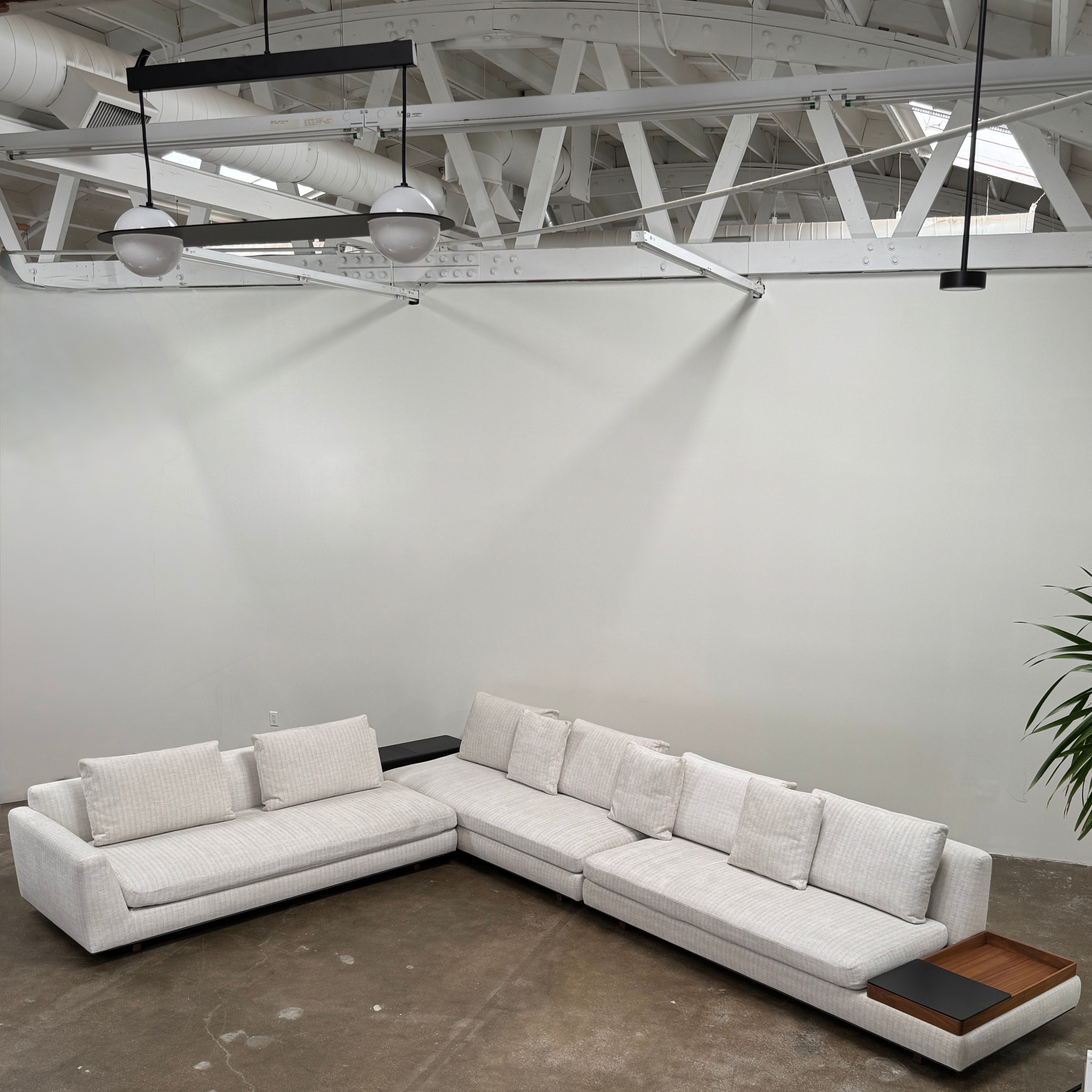 The Walter Knoll Tama Living 3 Piece Modular Sofa by Walter Knoll features an L-shaped design in light gray luxury fabric, matching cushions, and a built-in wooden side table on the right.