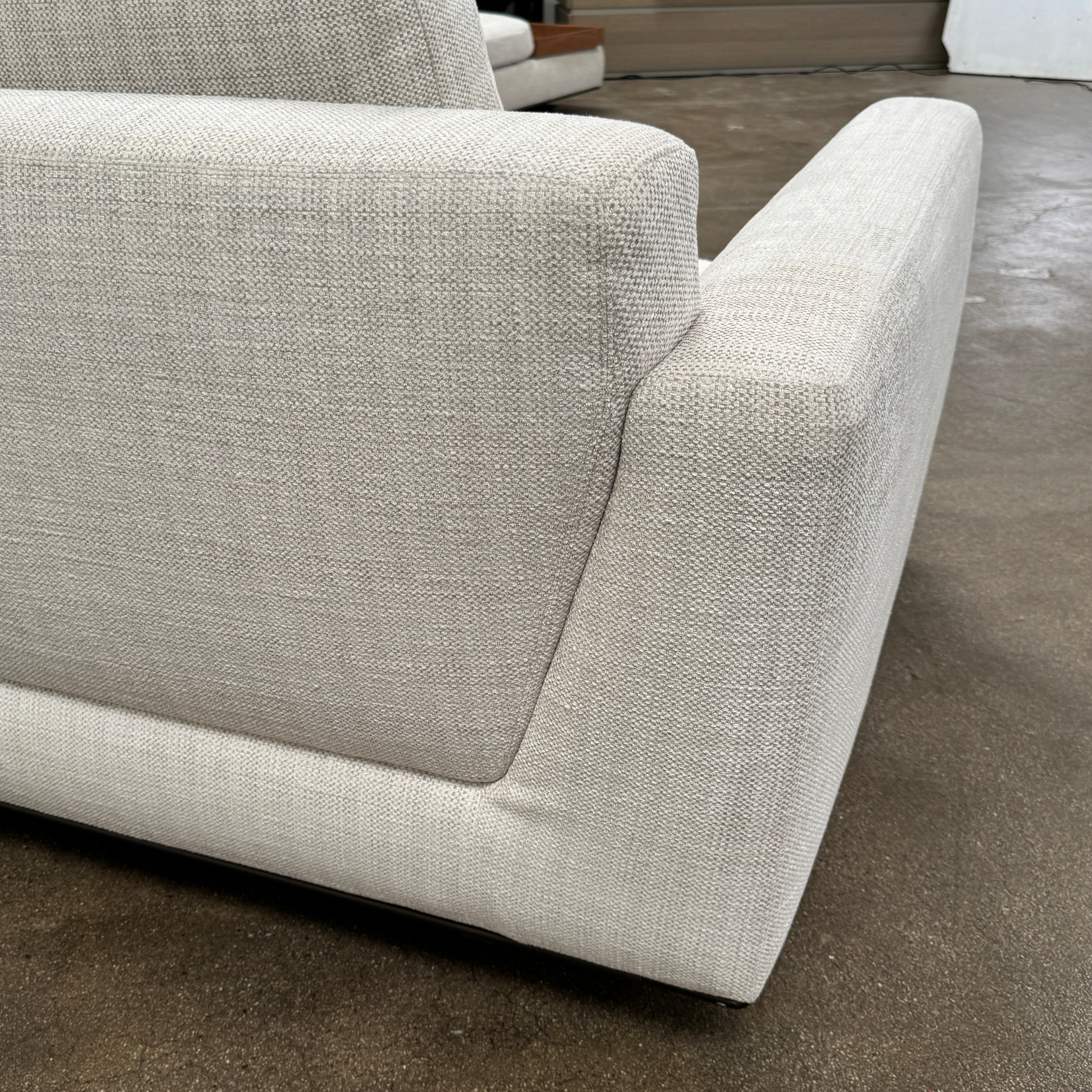 The Walter Knoll Tama Living 3 Piece Modular Sofa by Walter Knoll features an L-shaped design in light gray luxury fabric, matching cushions, and a built-in wooden side table on the right.