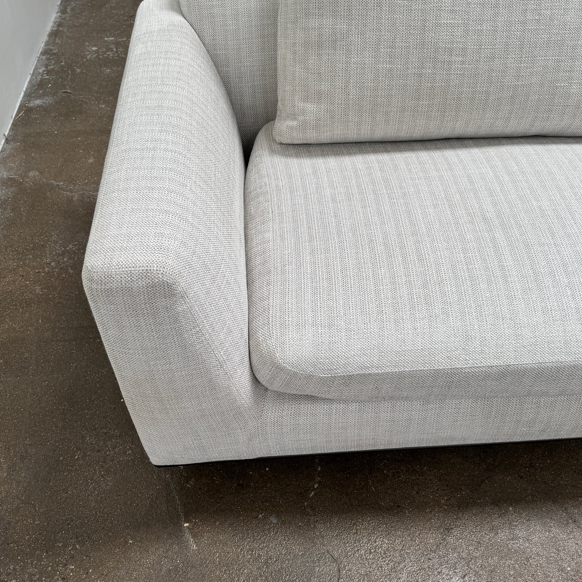 The Walter Knoll Tama Living 3 Piece Modular Sofa by Walter Knoll features an L-shaped design in light gray luxury fabric, matching cushions, and a built-in wooden side table on the right.