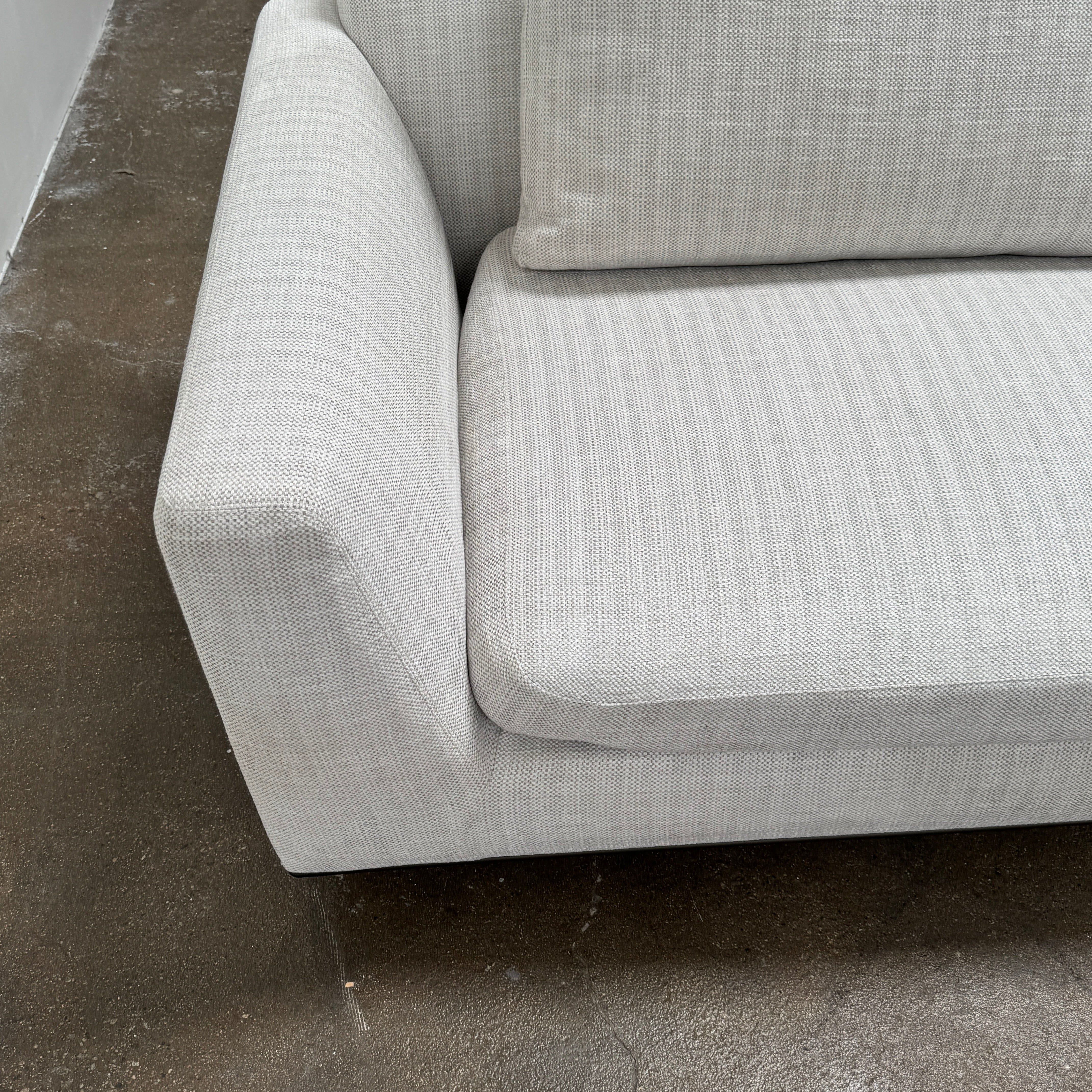 The Walter Knoll Tama Living 3 Piece Modular Sofa by Walter Knoll features an L-shaped design in light gray luxury fabric, matching cushions, and a built-in wooden side table on the right.