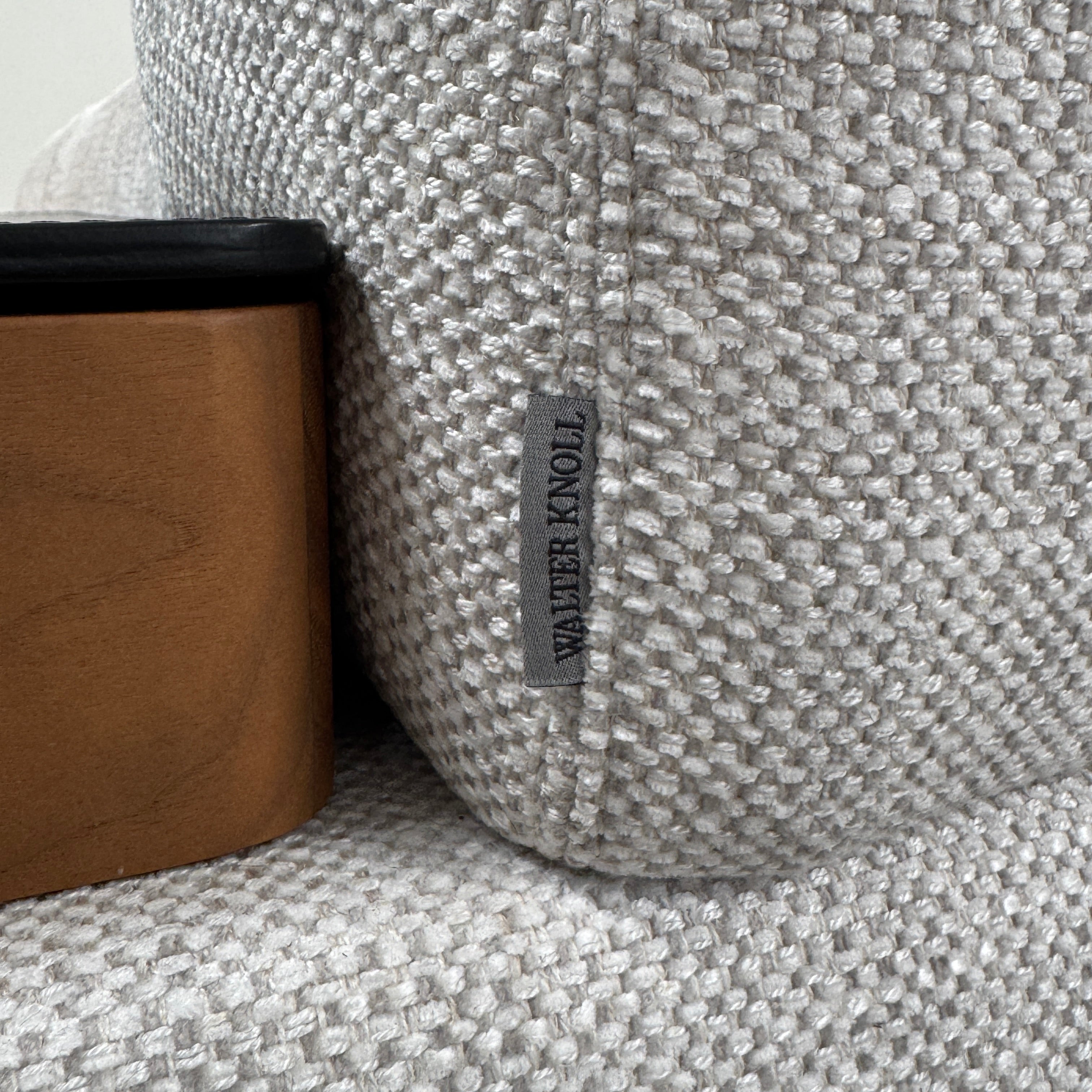 The Walter Knoll Tama Living 3 Piece Modular Sofa by Walter Knoll features an L-shaped design in light gray luxury fabric, matching cushions, and a built-in wooden side table on the right.
