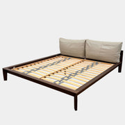 The Molteni&C Wish King Size Bed by Molteni & C features a solid wood frame with a slatted base, dark brown legs, and two large beige headboard cushions. Shown on a white background, it’s ideal for stylish and comfortable bedrooms.