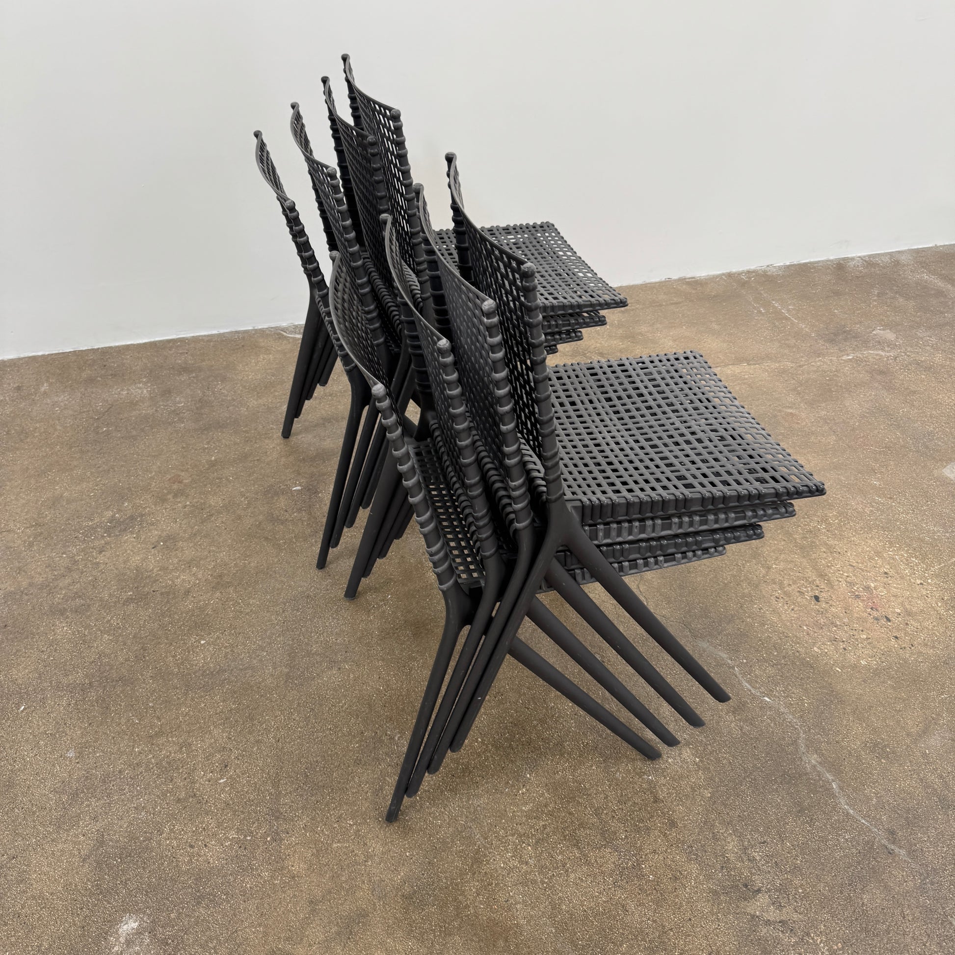 The Tribu Illum Outdoor Dining Table with 8 Chairs by Modern Resale features a sleek black finish and matching seating, set against a plain white background—an elegant choice for any modern outdoor space.