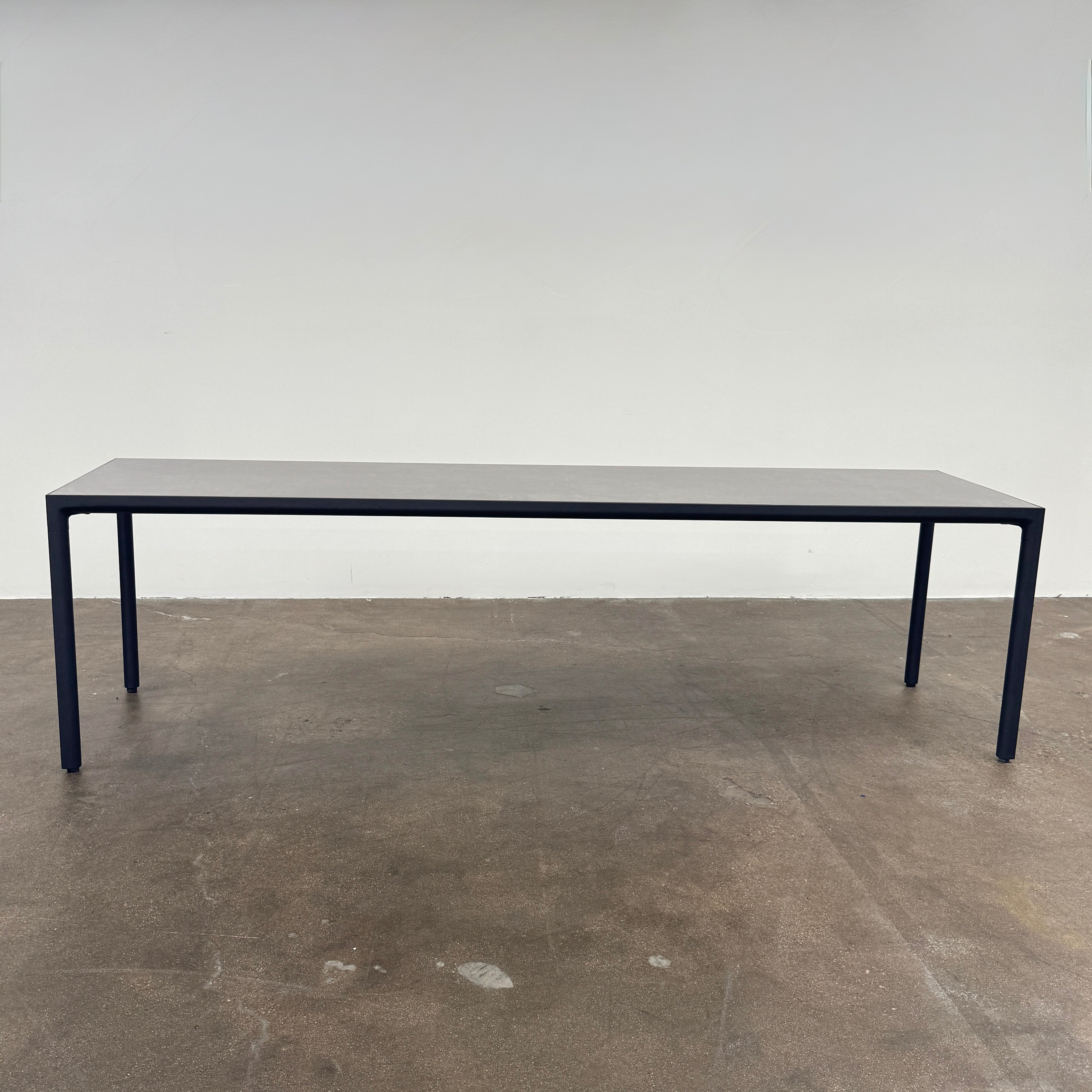 The Tribu Illum Outdoor Dining Table with 8 Chairs by Modern Resale features a sleek black finish and matching seating, set against a plain white background—an elegant choice for any modern outdoor space.