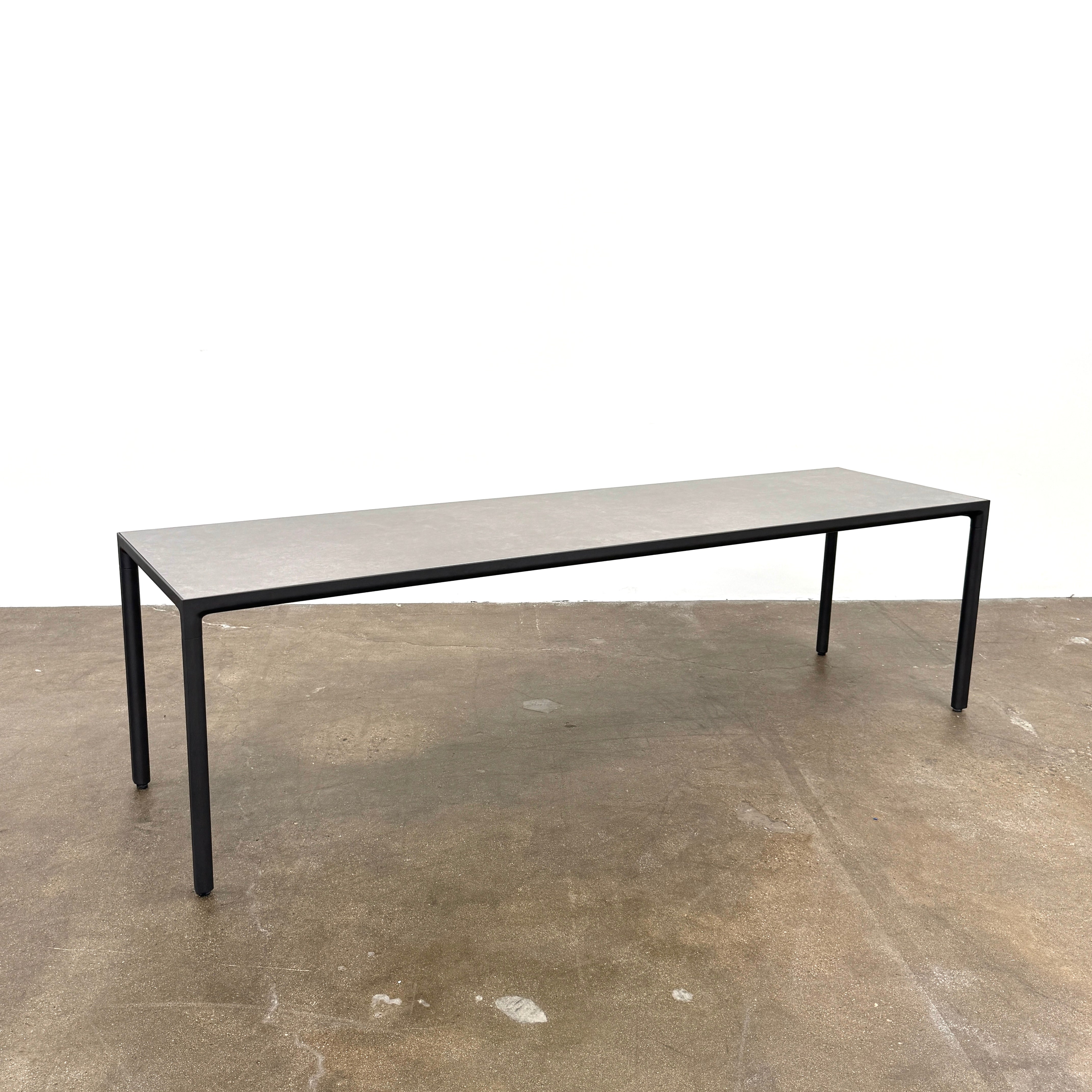 The Tribu Illum Outdoor Dining Table with 8 Chairs by Modern Resale features a sleek black finish and matching seating, set against a plain white background—an elegant choice for any modern outdoor space.
