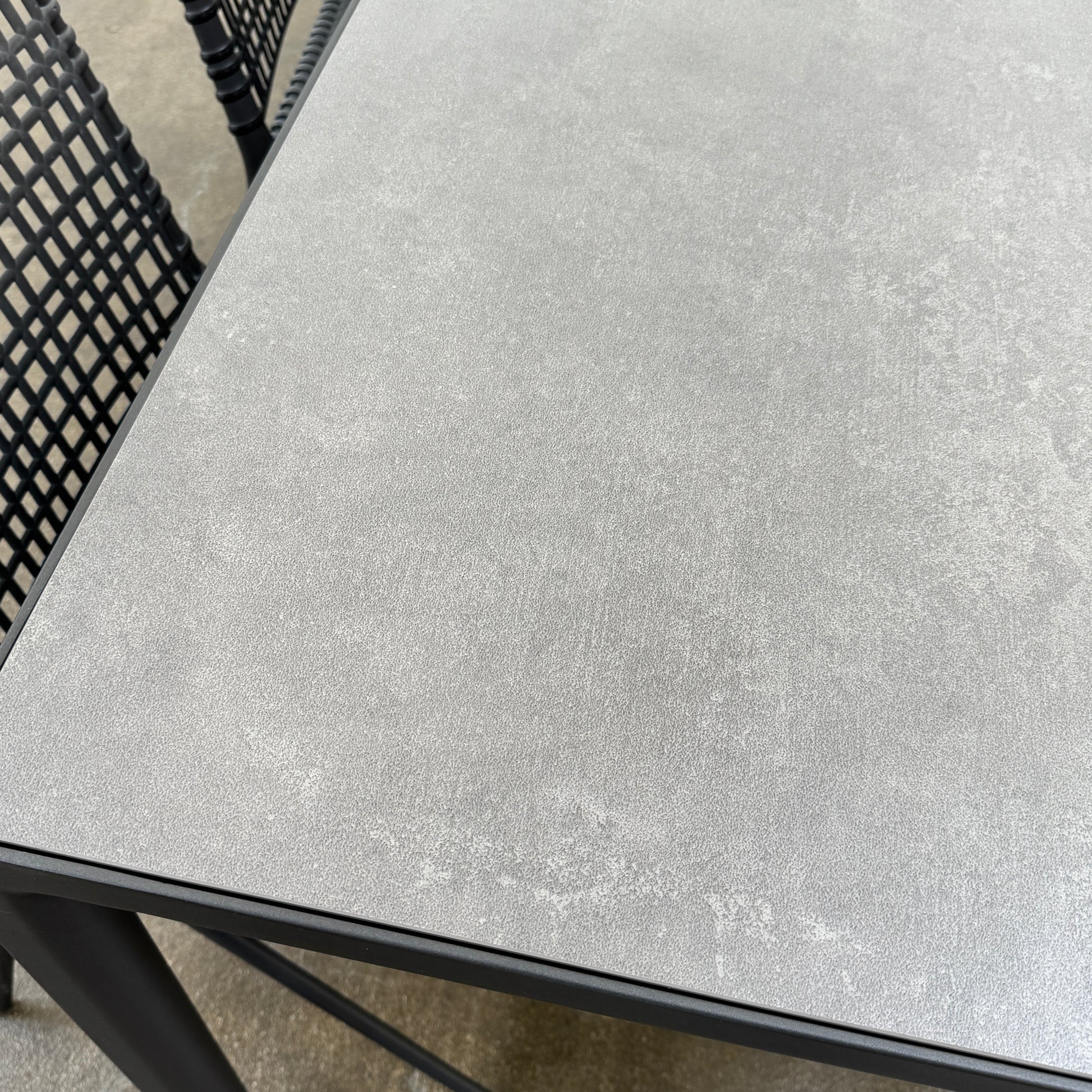 The Tribu Illum Outdoor Dining Table with 8 Chairs by Modern Resale features a sleek black finish and matching seating, set against a plain white background—an elegant choice for any modern outdoor space.