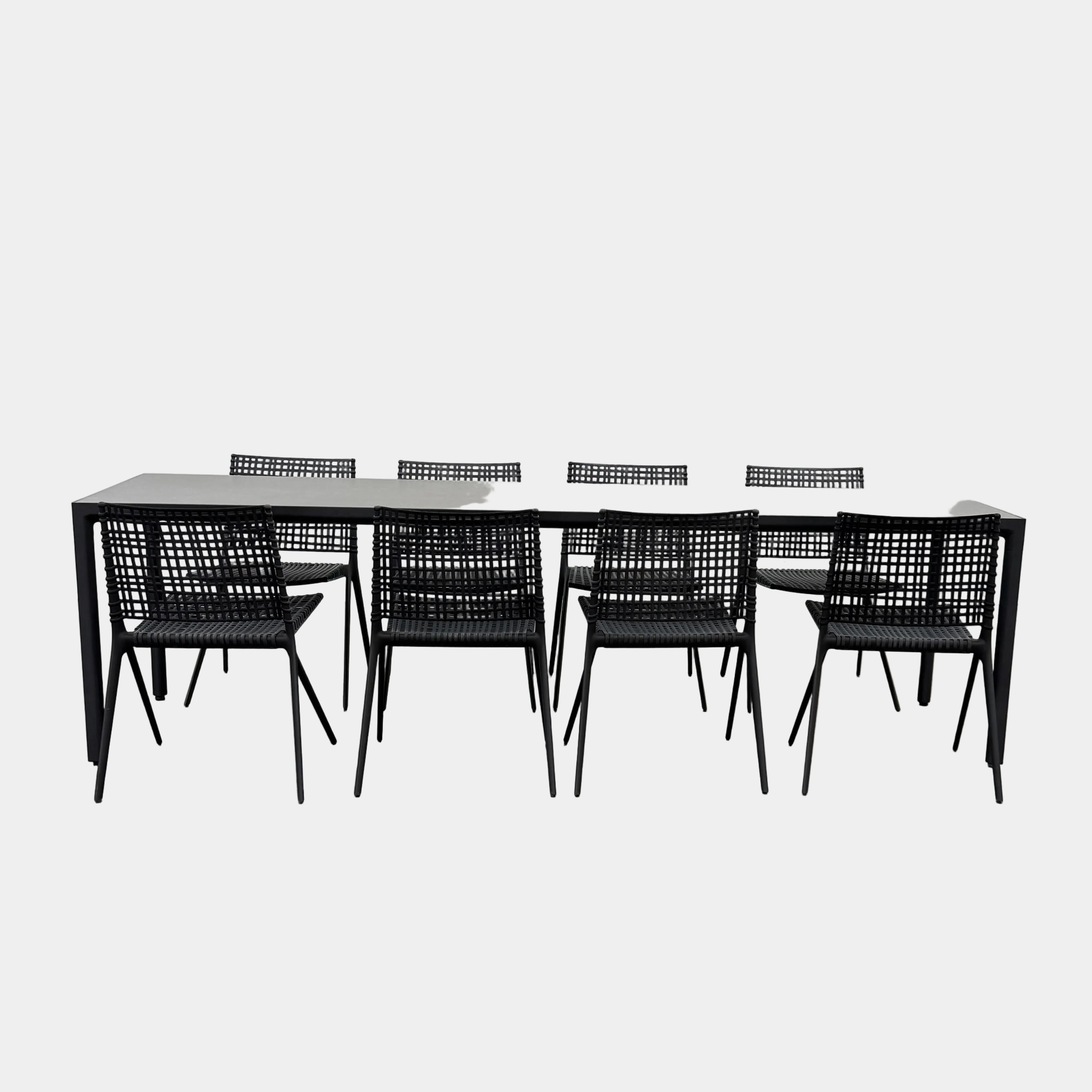 The Tribu Illum Outdoor Dining Table with 8 Chairs by Modern Resale features a sleek black finish and matching seating, set against a plain white background—an elegant choice for any modern outdoor space.
