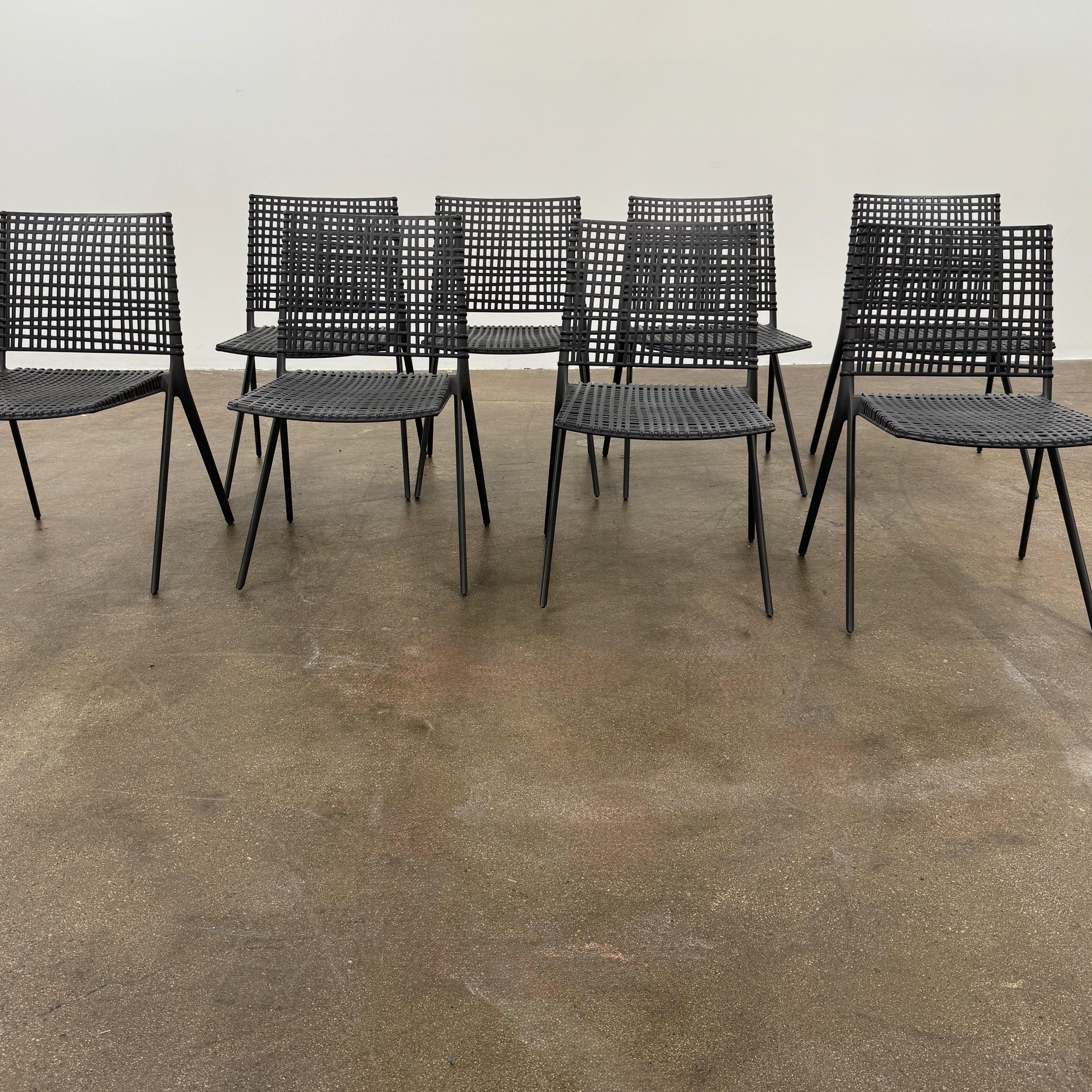 The Tribu Illum Outdoor Dining Table with 8 Chairs by Modern Resale features a sleek black finish and matching seating, set against a plain white background—an elegant choice for any modern outdoor space.