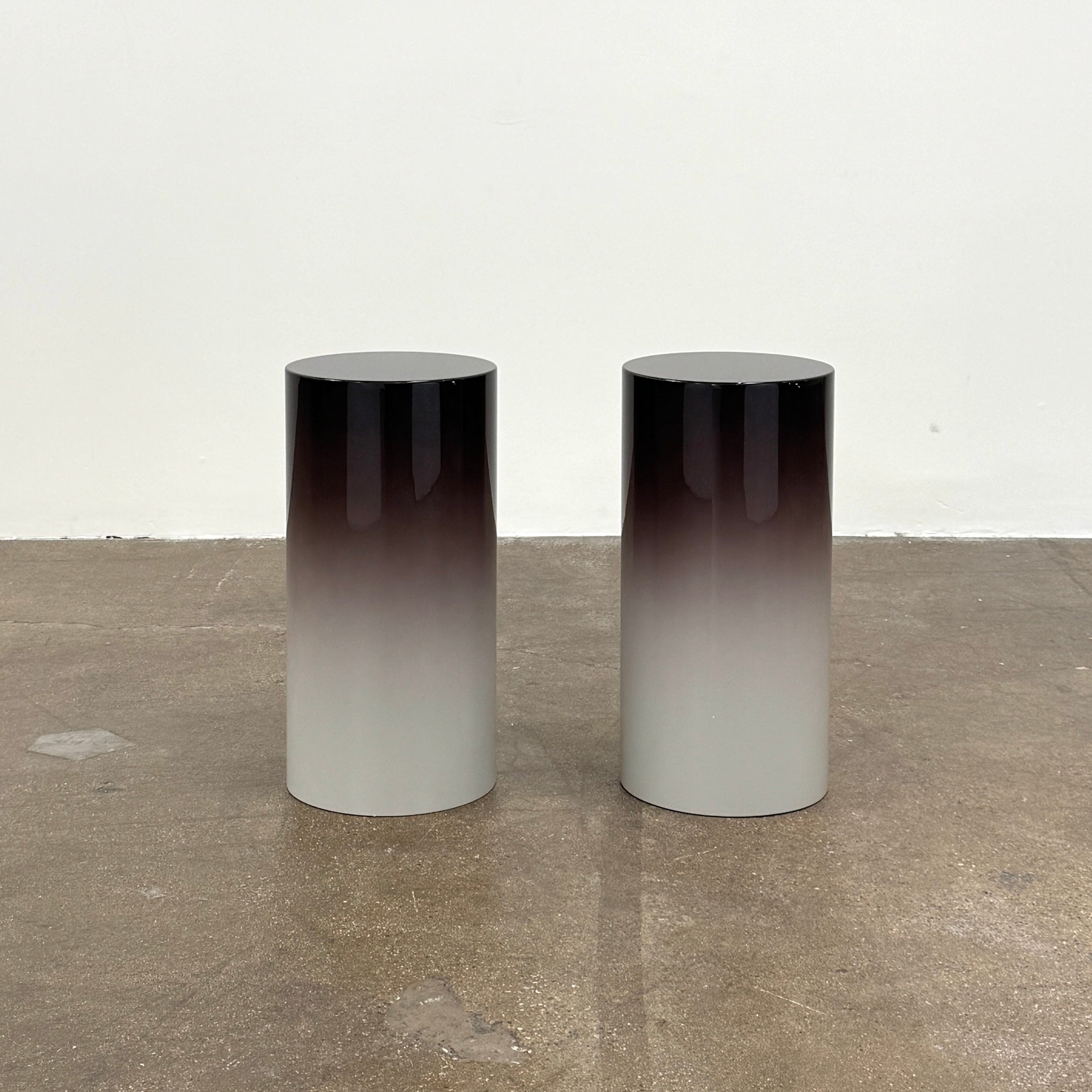 The Minotti Pilotis Accent Table by Minotti features a cylindrical form with a sleek gradient from black to white, adding a modern touch and elevating any contemporary interior furniture collection.
