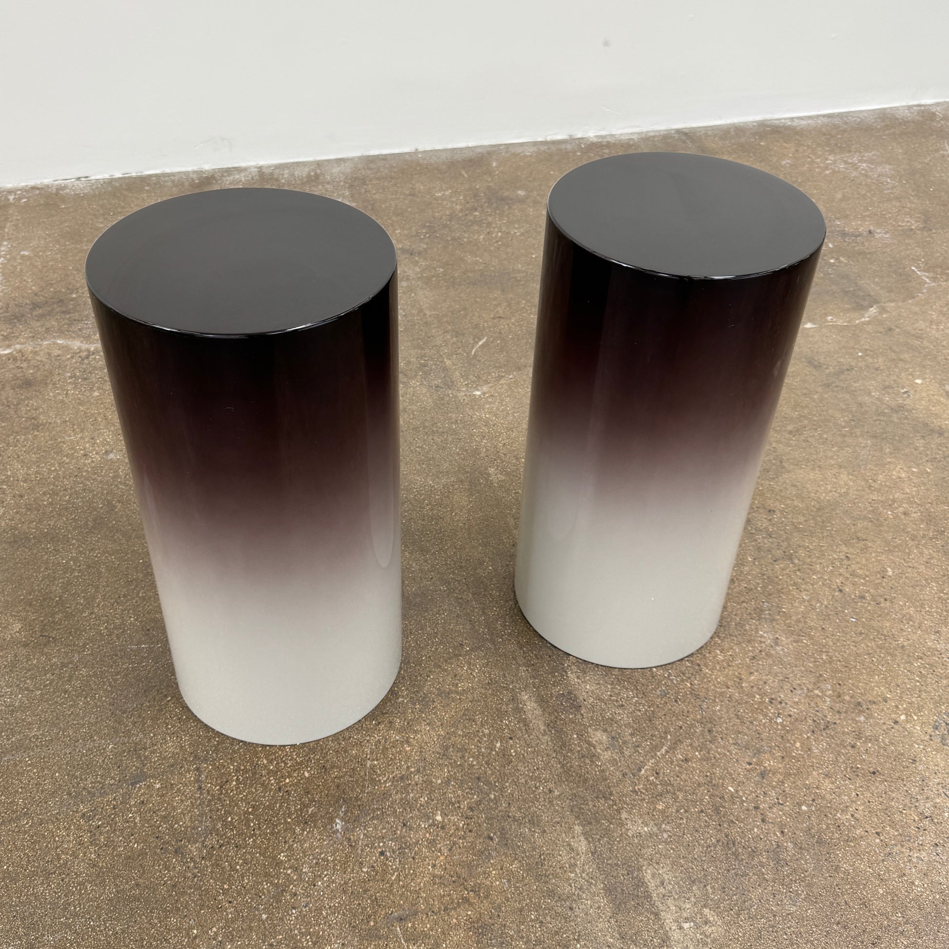The Minotti Pilotis Accent Table by Minotti features a cylindrical form with a sleek gradient from black to white, adding a modern touch and elevating any contemporary interior furniture collection.