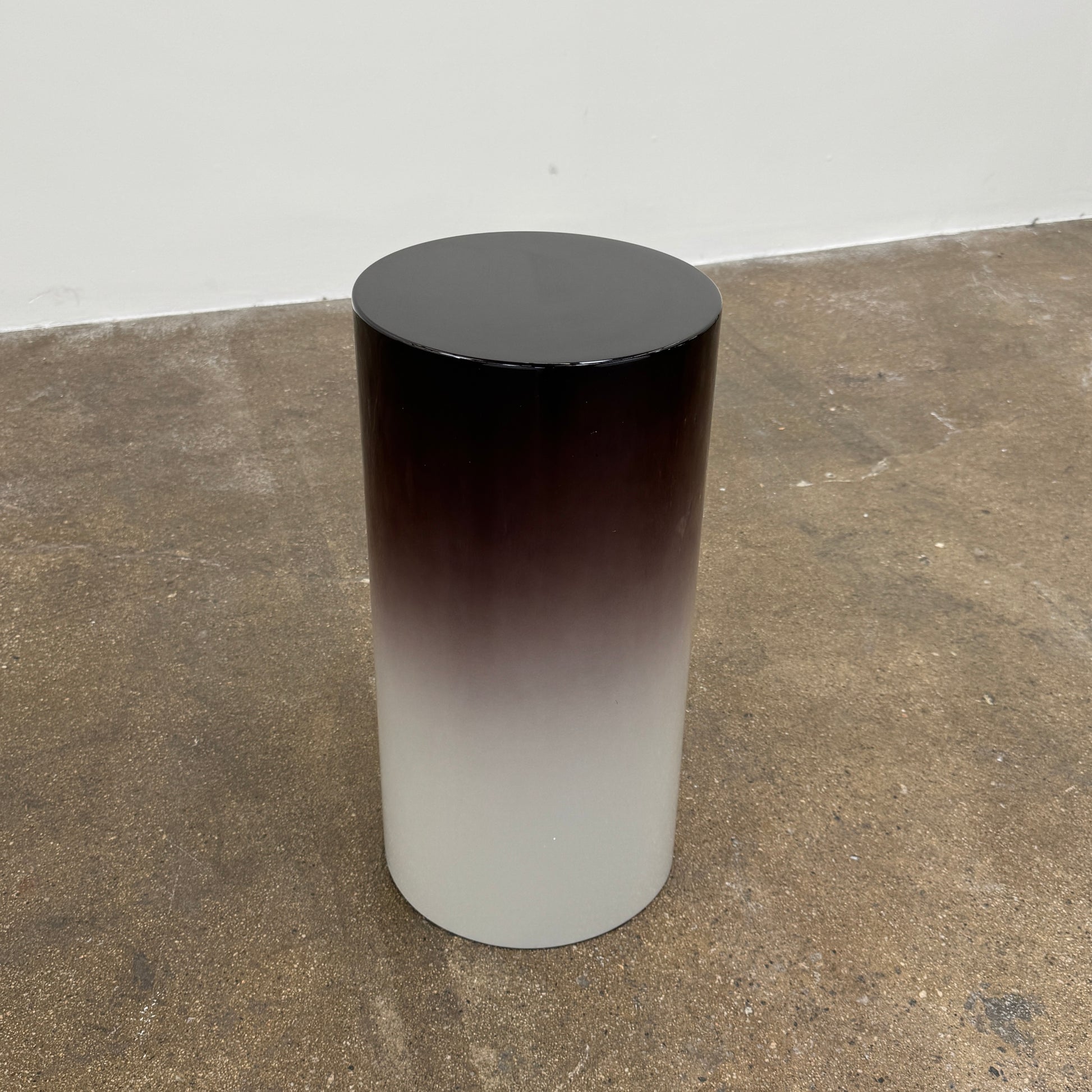 The Minotti Pilotis Accent Table by Minotti features a cylindrical form with a sleek gradient from black to white, adding a modern touch and elevating any contemporary interior furniture collection.