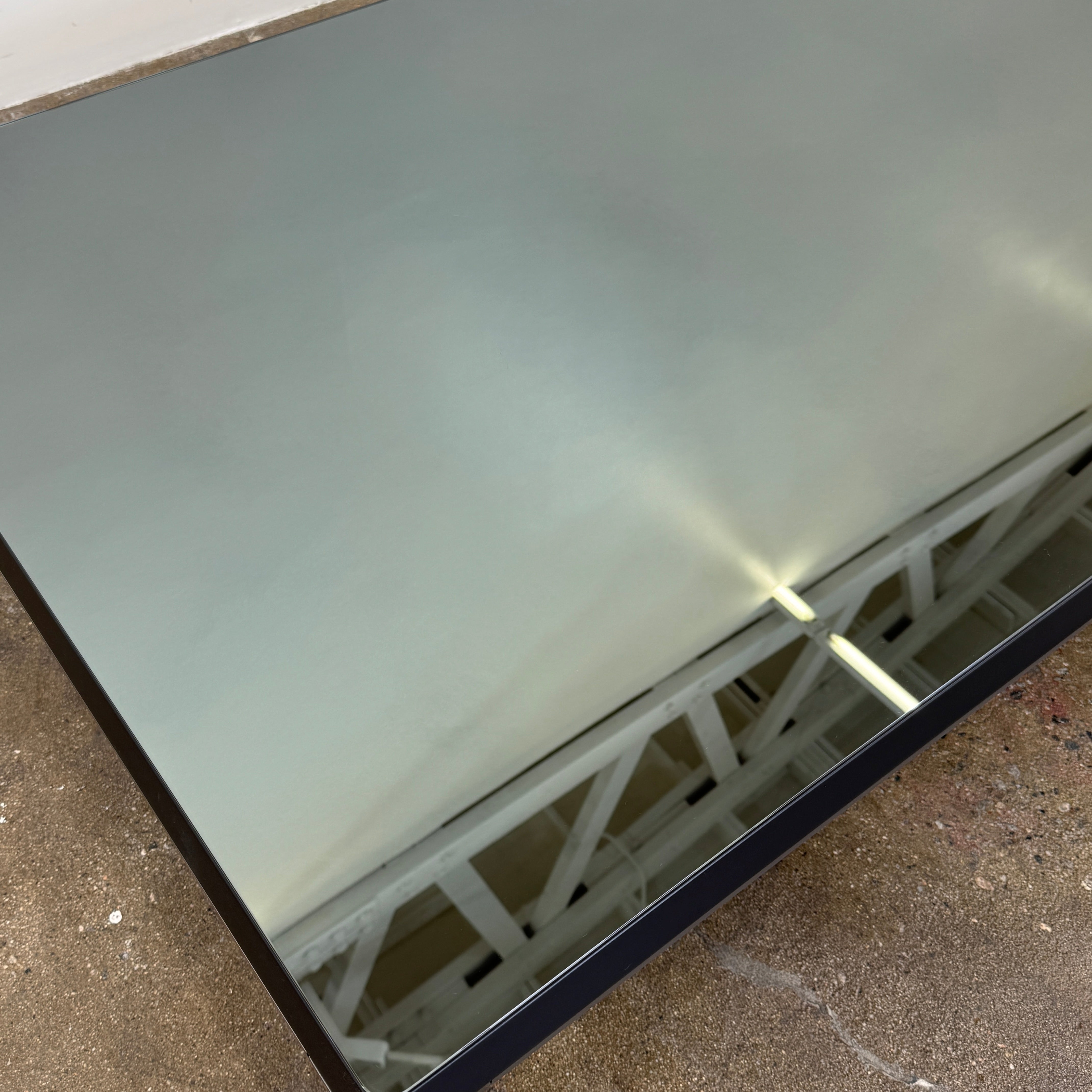 The B&B Italia Michel Coffee Table features a rectangular minimalist design with a flat gray surface and slim black metal legs, showcased against a plain white background.