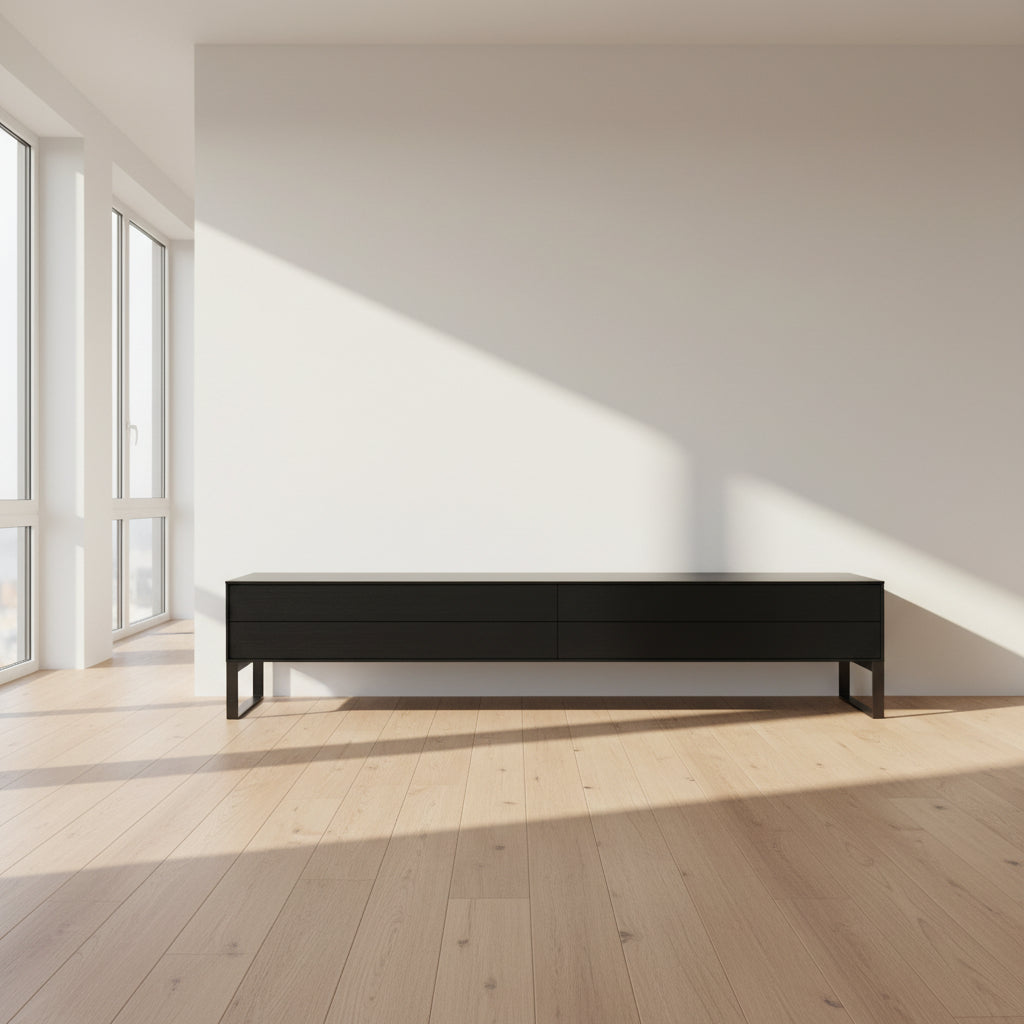 The Joan Lao Custom Media Console by Joan Lao is a black, modern low-profile piece made from sustainably sourced wood, featuring four drawers and open rectangular legs, shown against a plain white background.