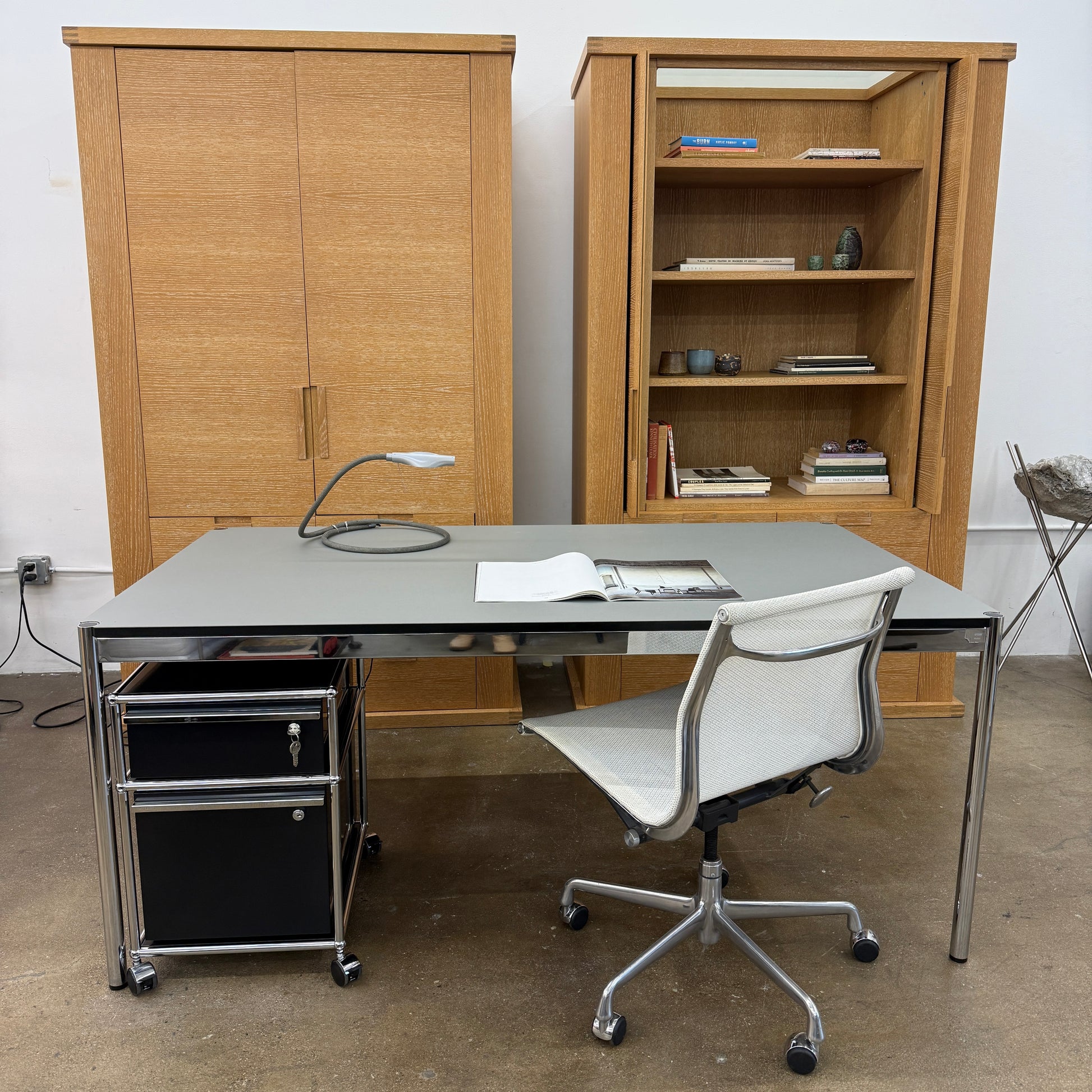 The Maxalto Apta Storage Unit by Maxalto features two vertical doors above and four bottom drawers in two rows, providing versatile storage with convenient shelves and drawers.