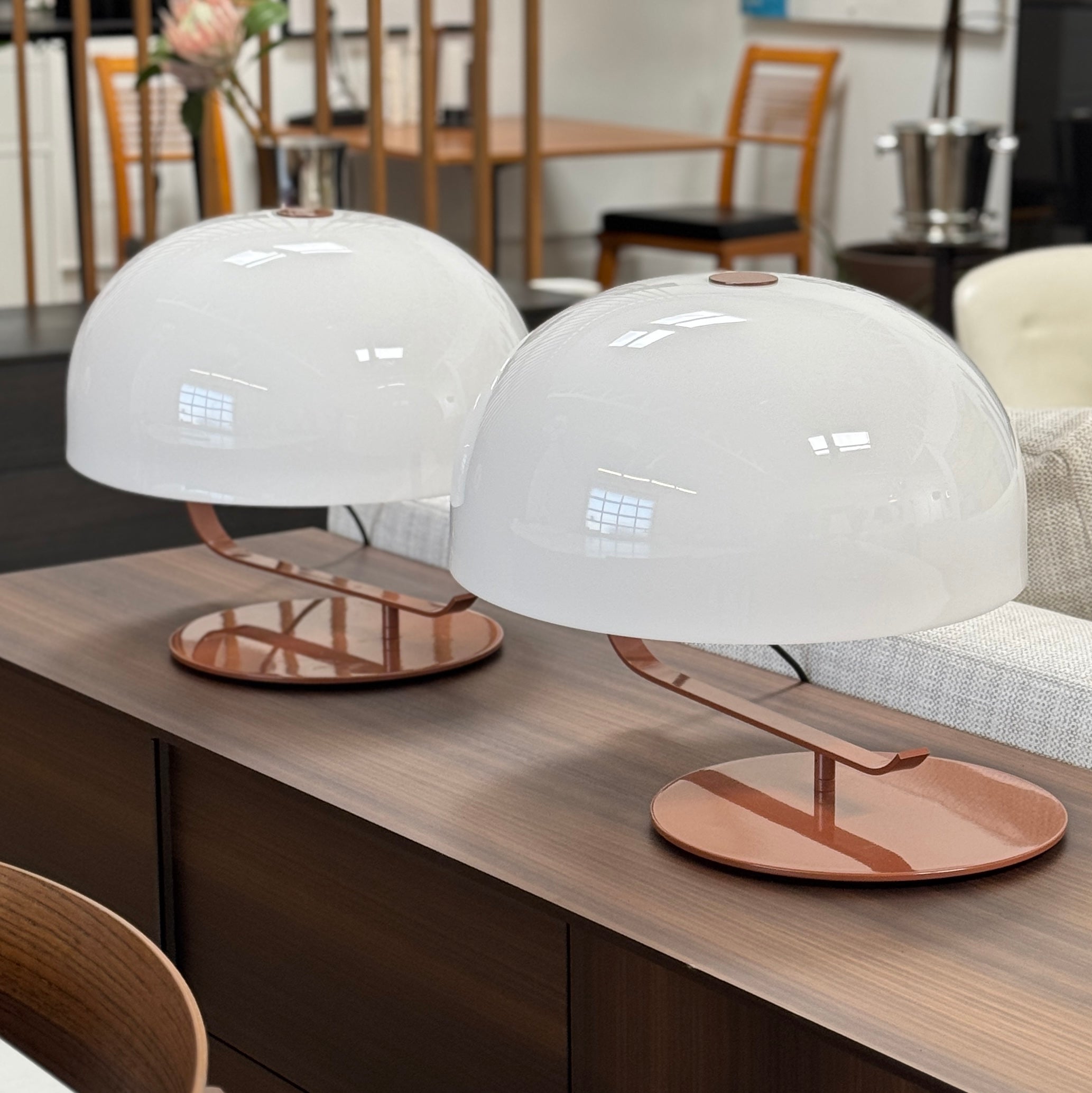 The Oluce Zanuso 275 Table Light by Oluce is a modern lamp inspired by Italian design, with a white domed glass shade, orange base, and black power cord with switch, shown against a plain background.