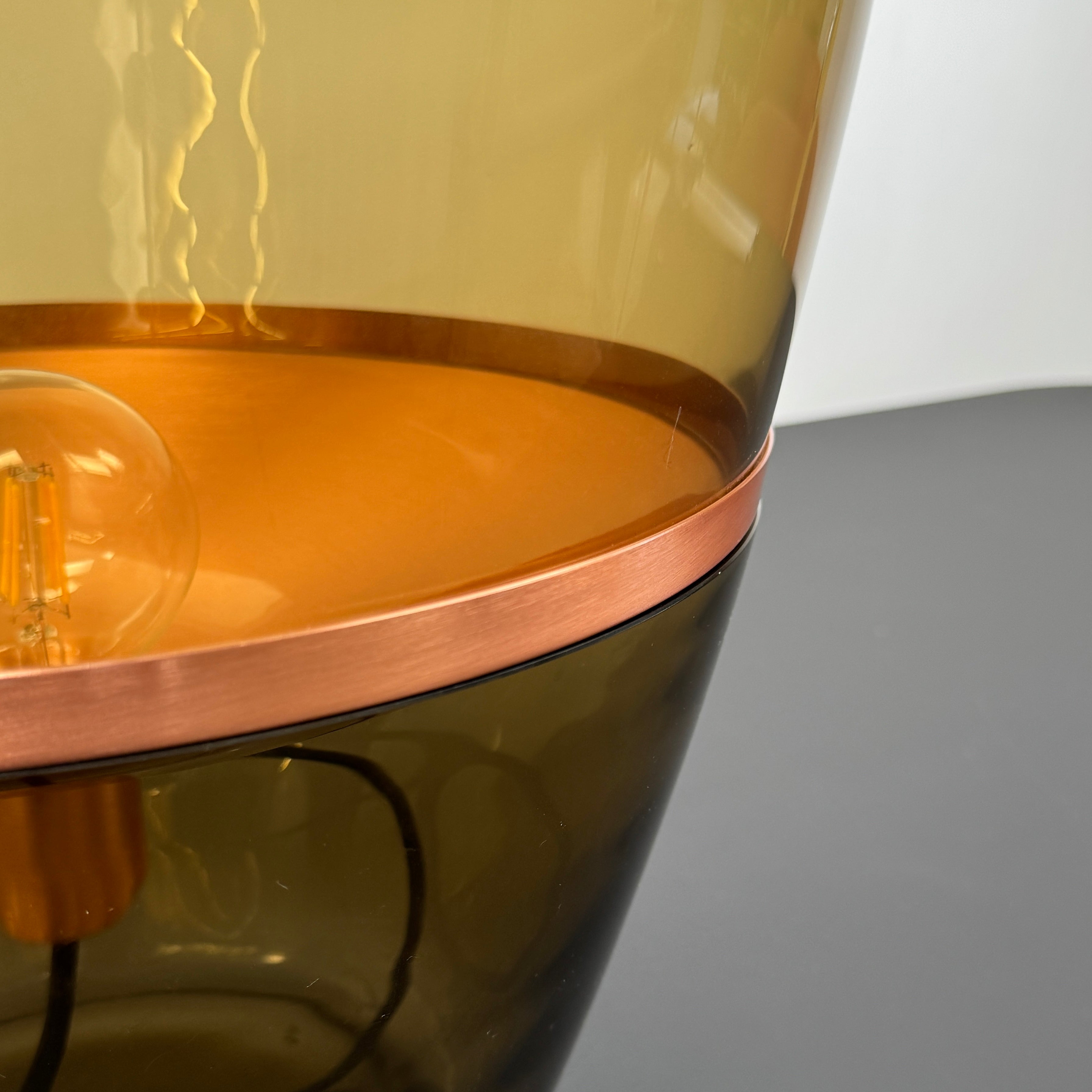 Three Brokis Balloons LED Lamps with handblown glass and copper accents are arranged side by side against a white background, highlighting their elegant sculptural design.