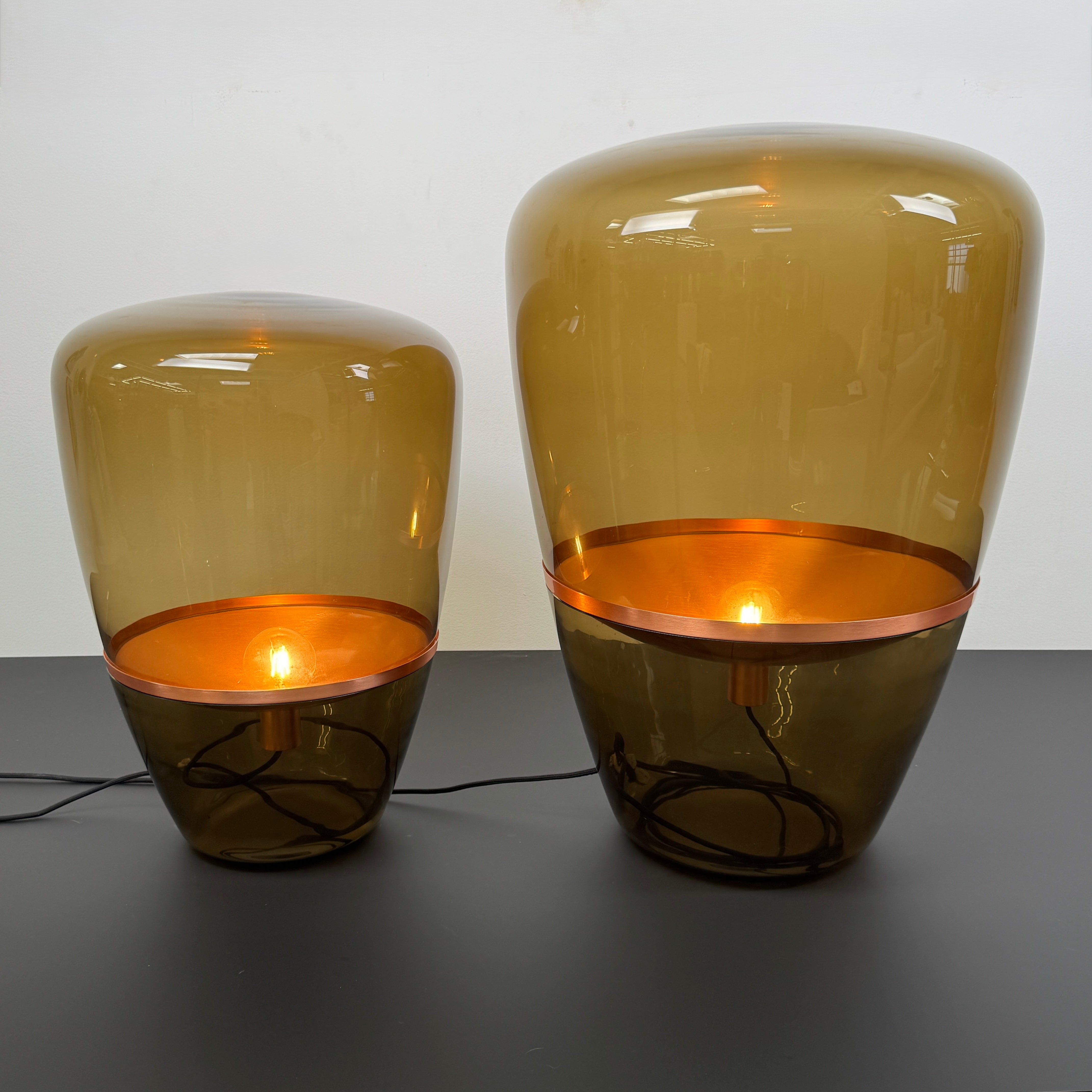 Three Brokis Balloons LED Lamps with handblown glass and copper accents are arranged side by side against a white background, highlighting their elegant sculptural design.