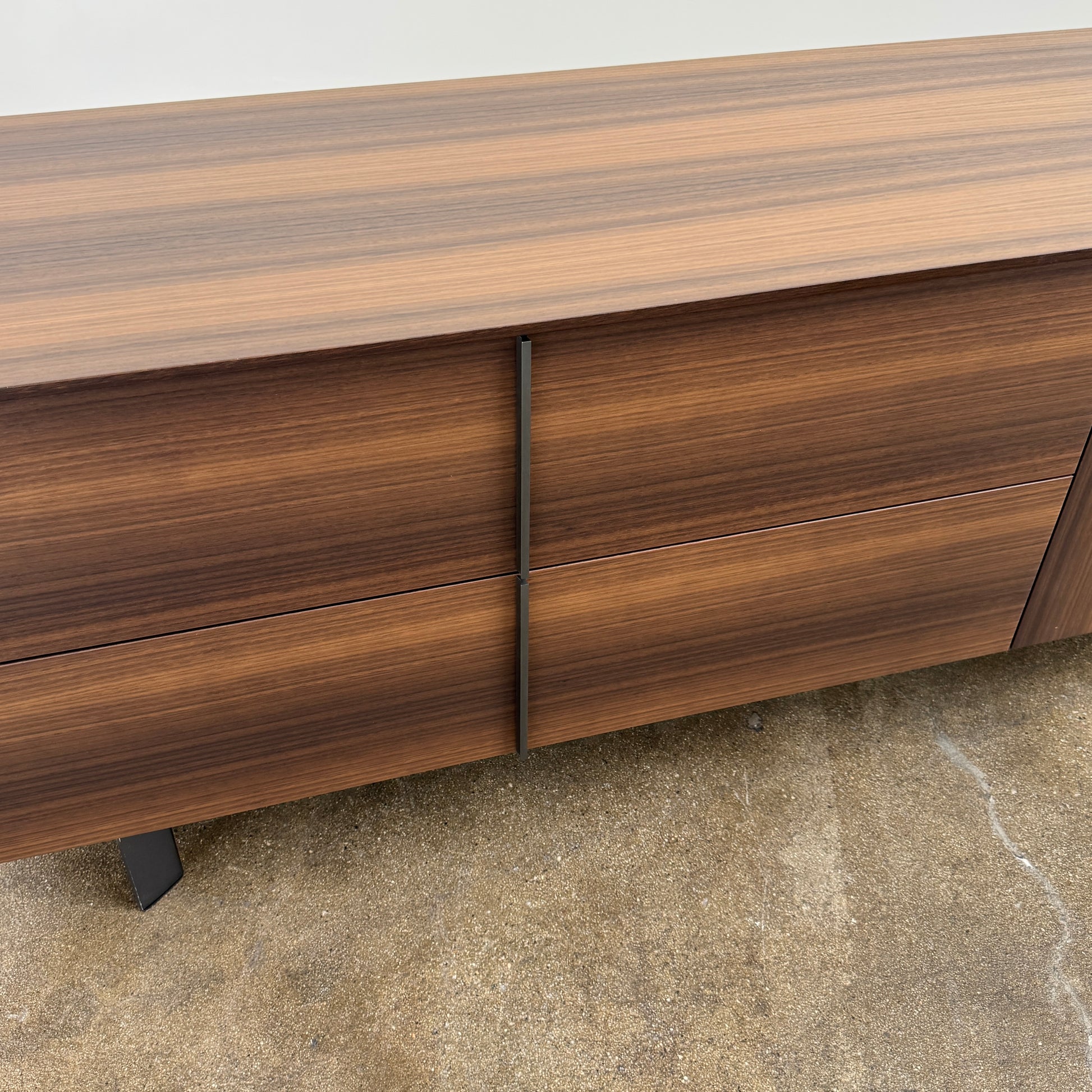 The Molteni & C Pass-word Console by Molteni & C is a modern, low-profile Eucalyptus wood sideboard with two drawers, cabinets on each side, and black metal legs, shown against a plain white background.
