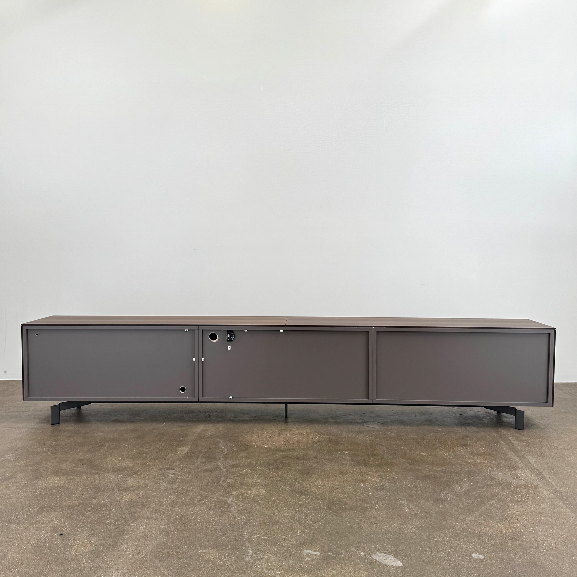 The Molteni & C Pass-word Console by Molteni & C is a modern, low-profile Eucalyptus wood sideboard with two drawers, cabinets on each side, and black metal legs, shown against a plain white background.
