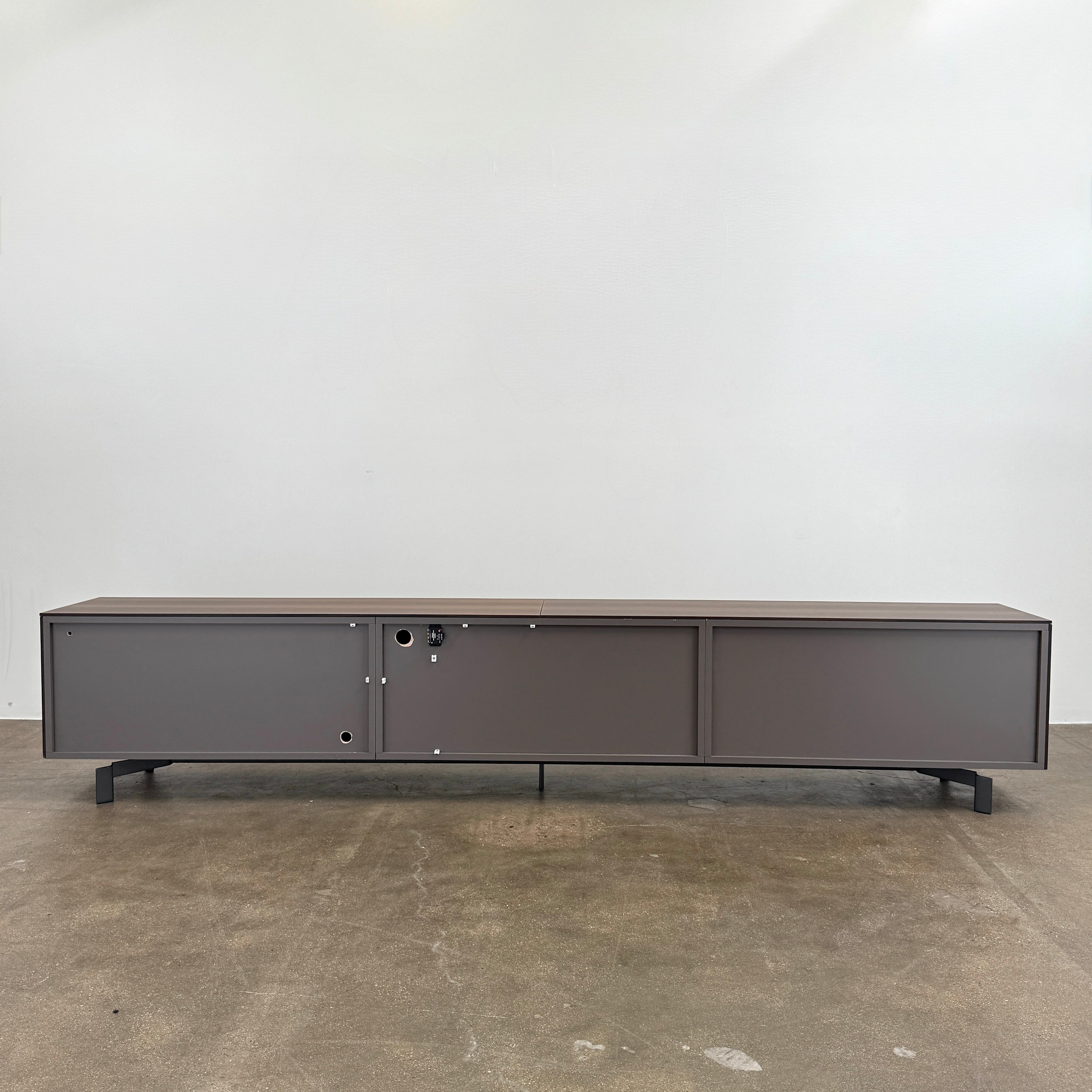 The Molteni & C Pass-word Console by Molteni & C is a modern, low-profile Eucalyptus wood sideboard with two drawers, cabinets on each side, and black metal legs, shown against a plain white background.