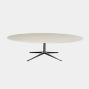 Florence Knoll’s DWR Florence Knoll Oval White Statuarietto Marble "Table Desk" features a slim marble top and black four-legged base, inspired by the iconic design, displayed against a plain white background.