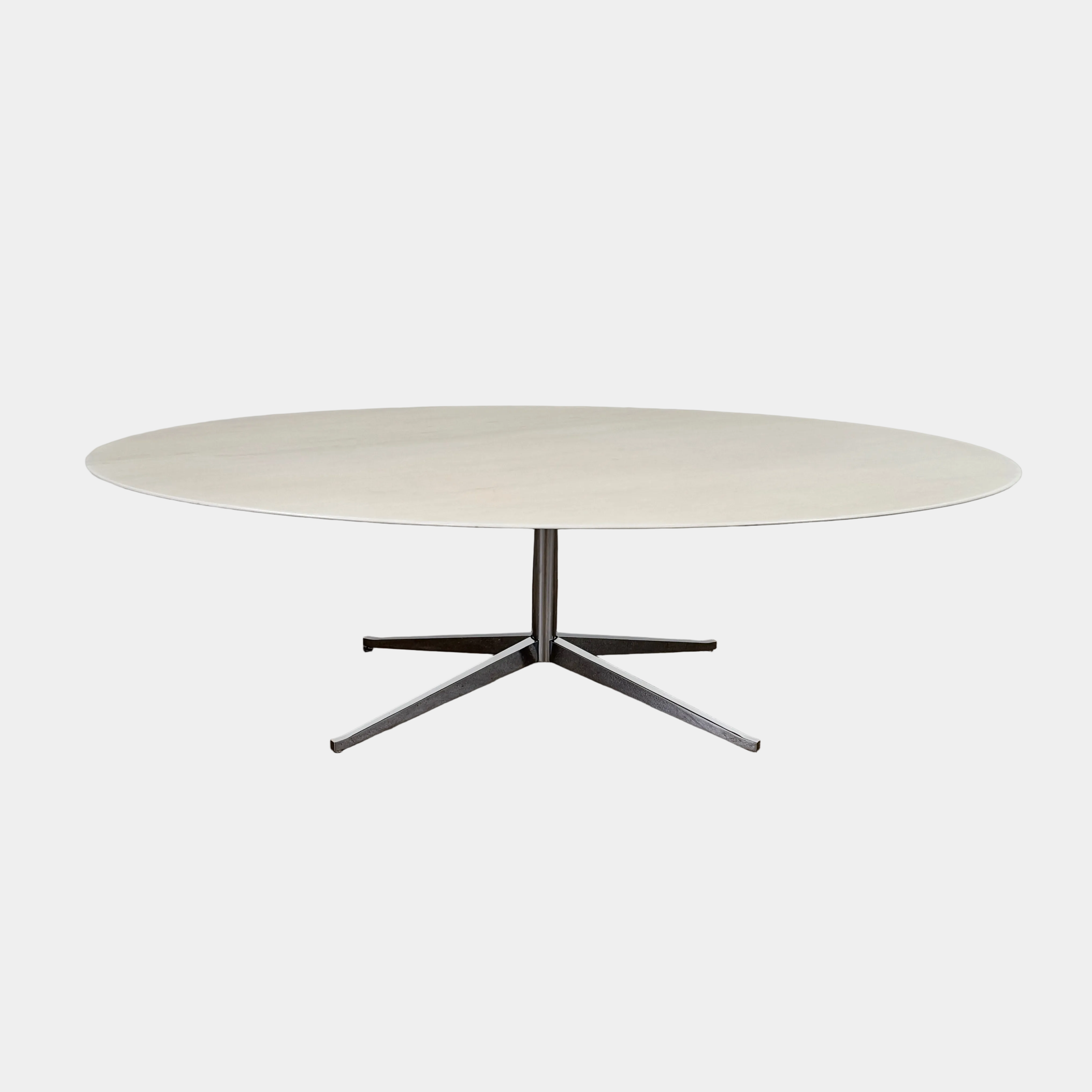 Florence Knoll’s DWR Florence Knoll Oval White Statuarietto Marble "Table Desk" features a slim marble top and black four-legged base, inspired by the iconic design, displayed against a plain white background.