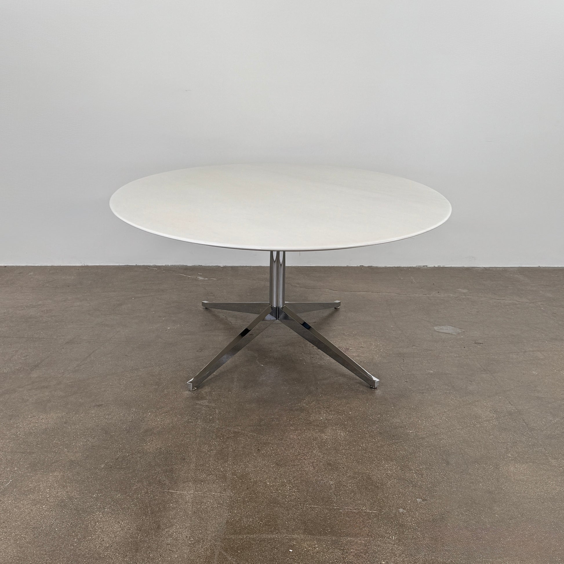 Florence Knoll’s DWR Florence Knoll Oval White Statuarietto Marble "Table Desk" features a slim marble top and black four-legged base, inspired by the iconic design, displayed against a plain white background.