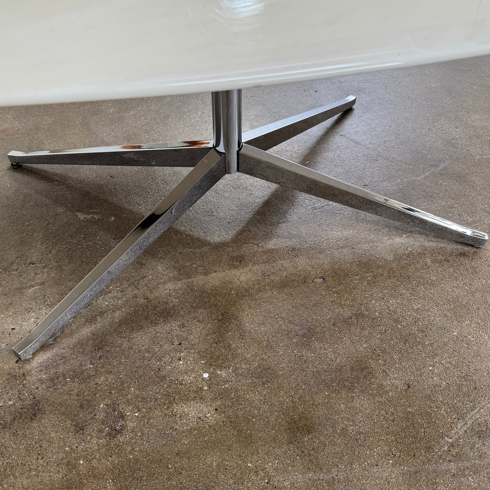 Florence Knoll’s DWR Florence Knoll Oval White Statuarietto Marble "Table Desk" features a slim marble top and black four-legged base, inspired by the iconic design, displayed against a plain white background.