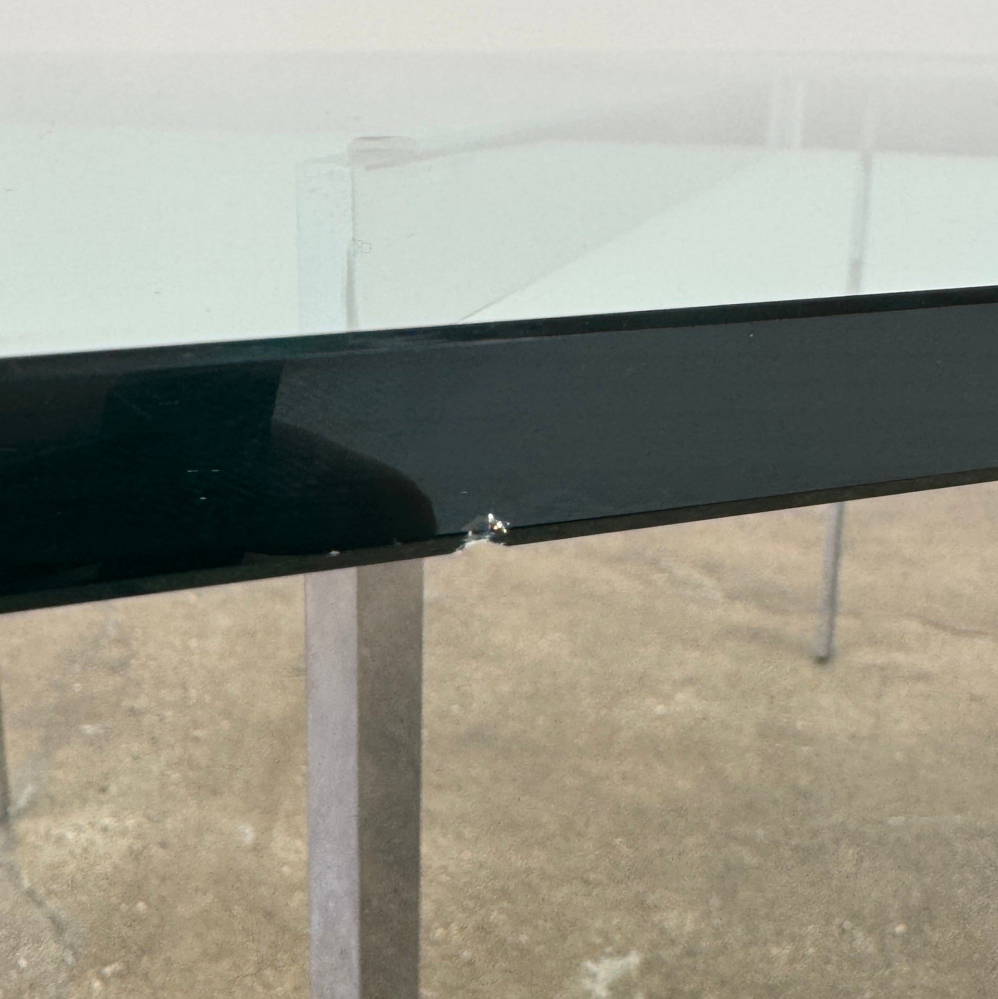 The Vintage DWR Barcelona Coffee Table by DWR features a rectangular glass top, four metal legs, and a visible metal support frame underneath.