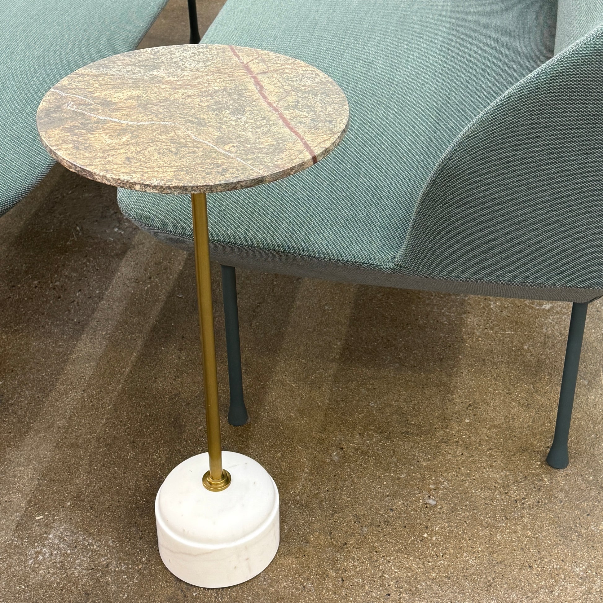 The Soho Home Fleet Side Table by Soho Home features a dark Verde Bosque marble top, slender antique brass stem, and a white cylindrical marble base, shown against a plain light background.