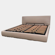 The DWR Nest King Size Leather Bed features a beige upholstered headboard and base, exposed wooden slats, and a sturdy metal support structure for enhanced durability.