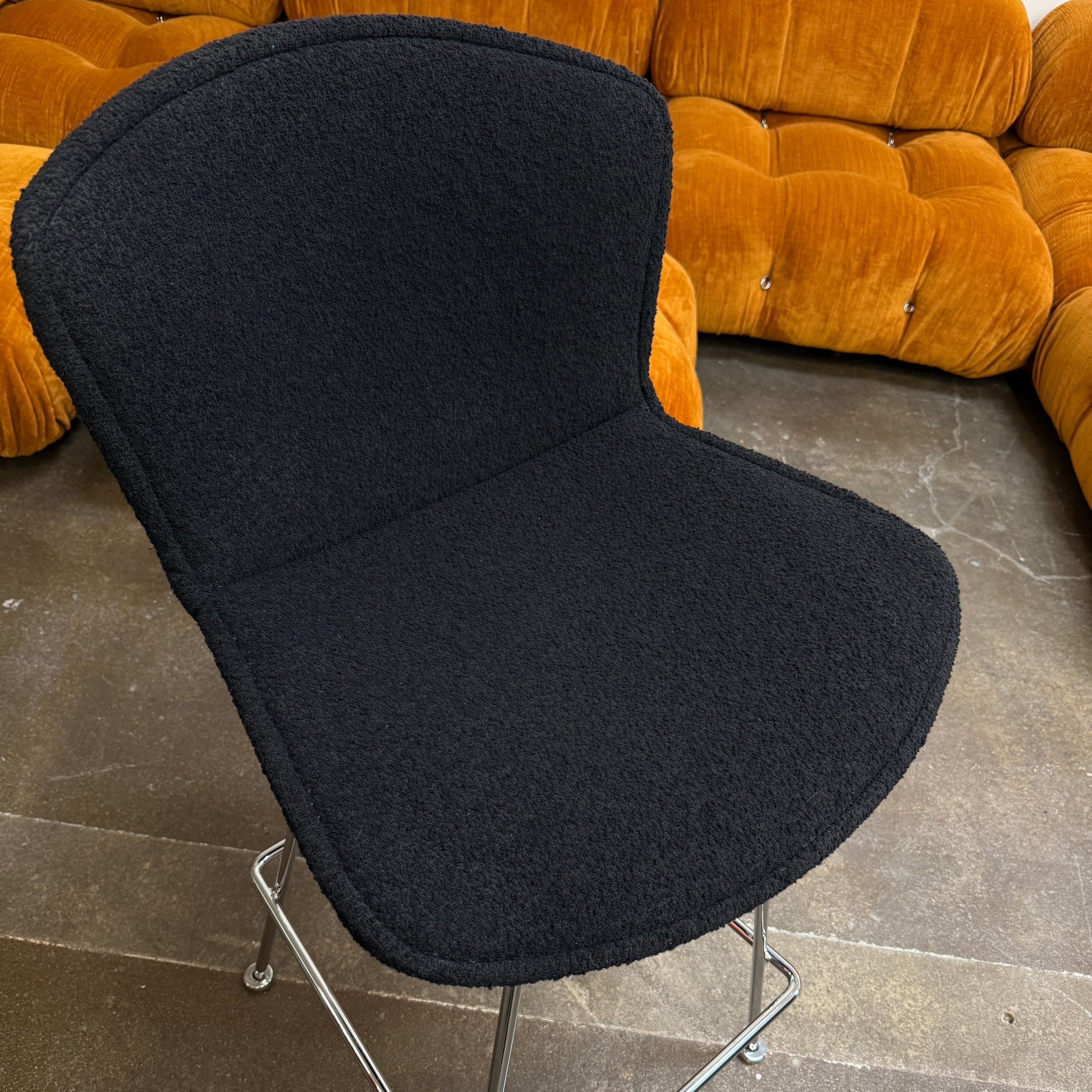 A set of four Knoll Bertoia Bar Stools by Knoll, featuring black upholstery and sleek metal legs, are displayed in two rows against a plain white background.