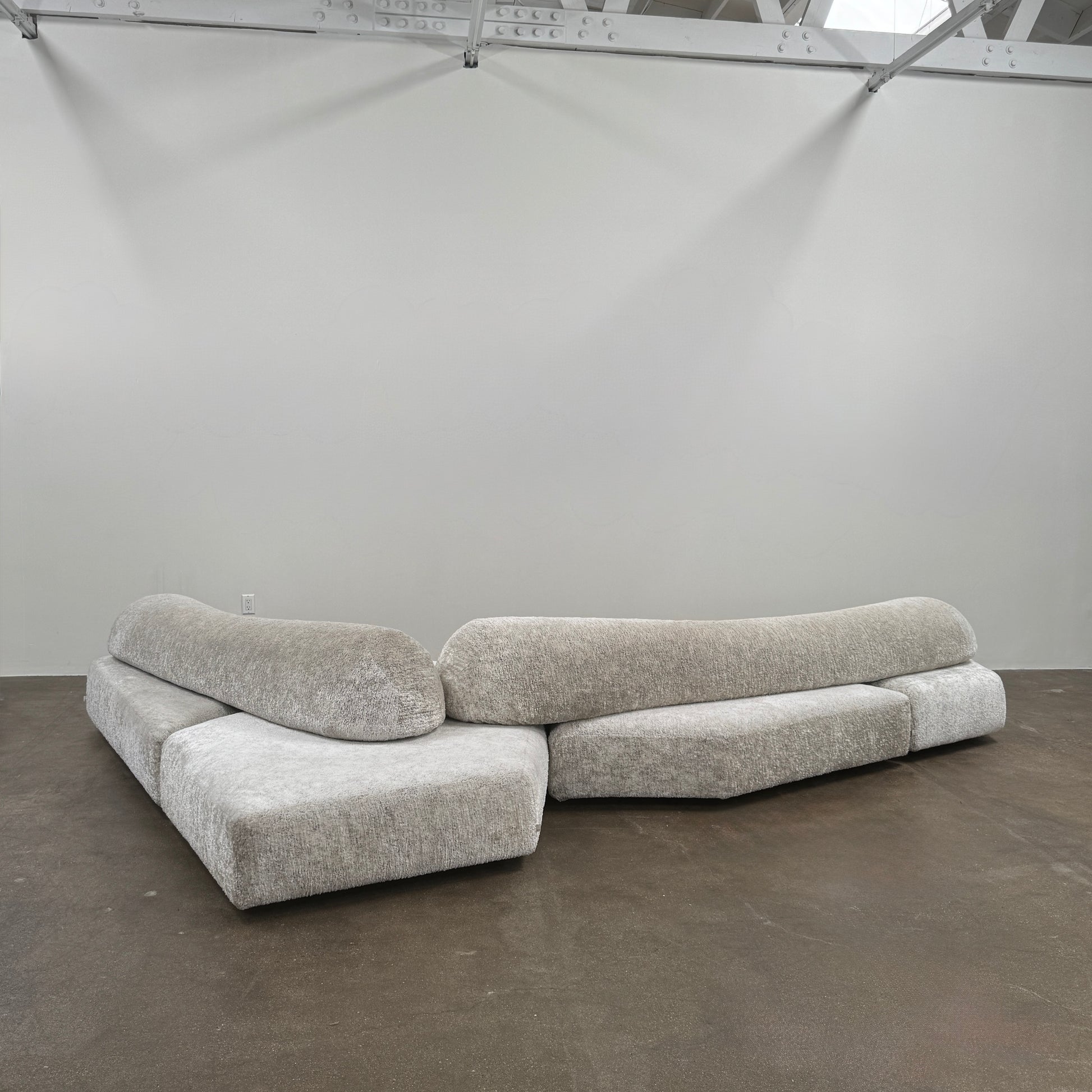 The Edra On The Rocks 4 piece Modular Sofa by Edra is a modern, light gray L-shaped sofa with customizable seating, featuring low rounded backrests and wide flat cushions, shown on a plain white background.